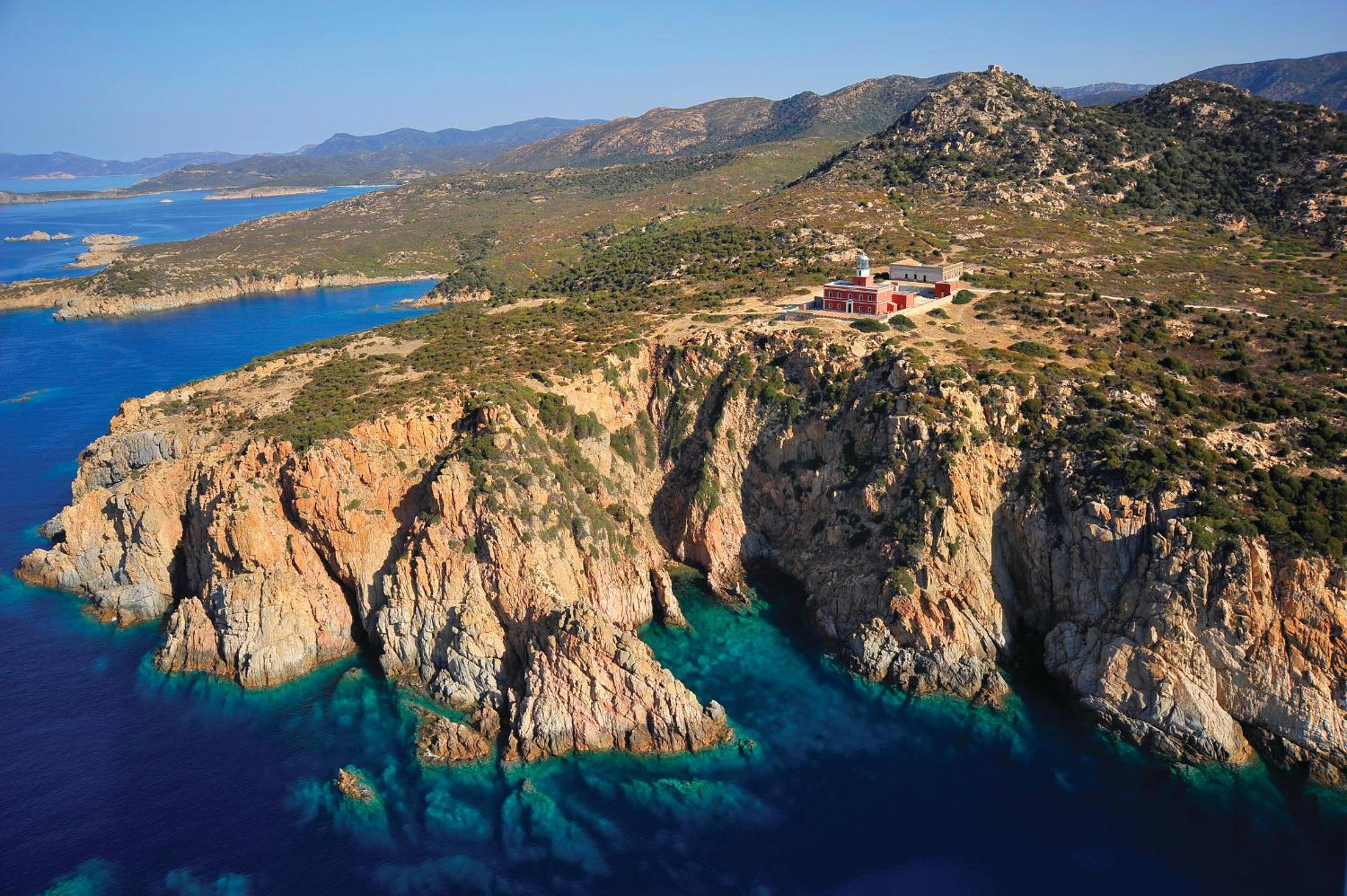 Dramatic limestone cliffs plunge into crystalline turquoise waters, while the modern hotel perches confidently above this rugged Mediterranean coastline like a contemporary sentinel.