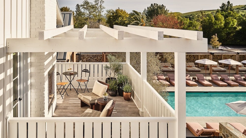 Afternoon light catches the white pergola overhead as loungers line the turquoise pool below — Mattei's Tavern balances Wine Country ease with unhurried elegance.