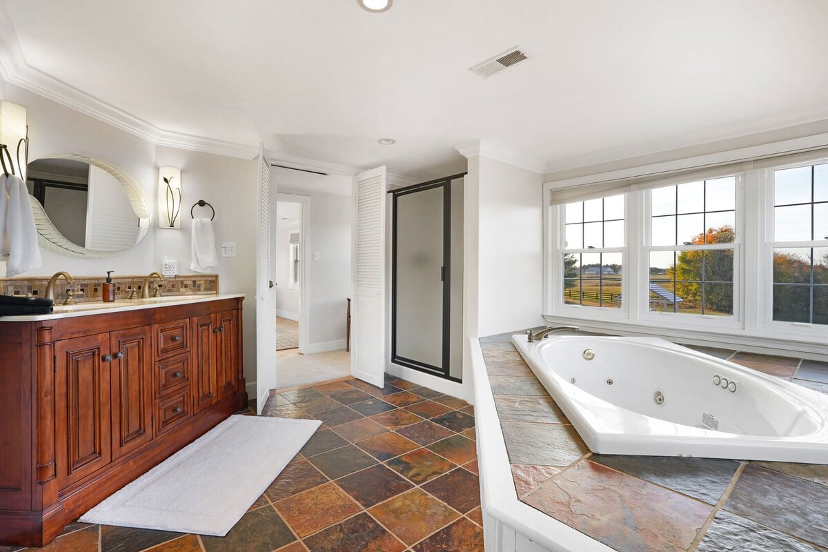 Full Bath 1 located through bedroom 1 with standing shower and soaker tub.