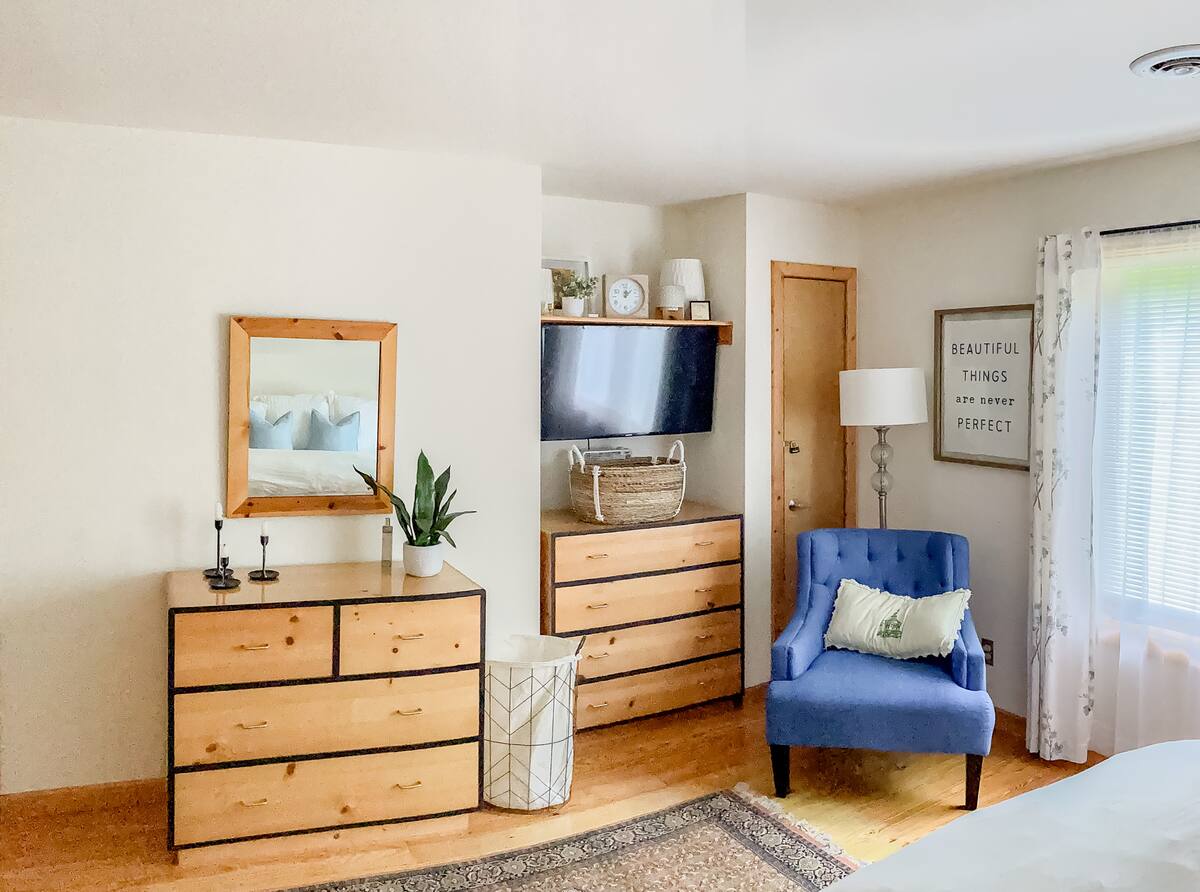 Primary bedroom includes king bed, dresser, and TV