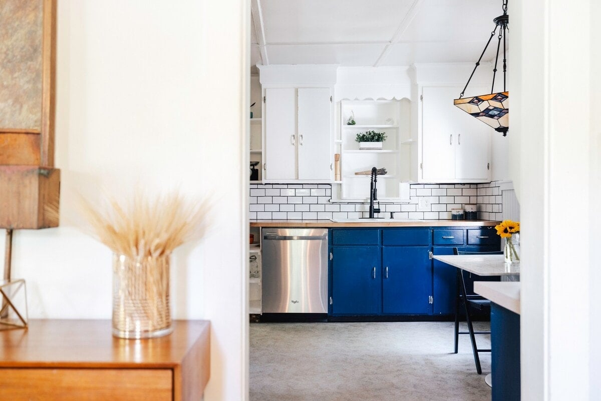 Discover the charm of "Property," a luxurious retreat in Woodstock, US. The property features a blend of rustic and modern architectural style, with vibrant blue cabinetry and sleek white tiles adorning the kitchen. The atmosphere is cozy yet elegant, accented by a warm, natural color palette with touches of modern art. Ideal for travelers seeking a serene escape, the space offers an inviting ambiance and stylish comfort.