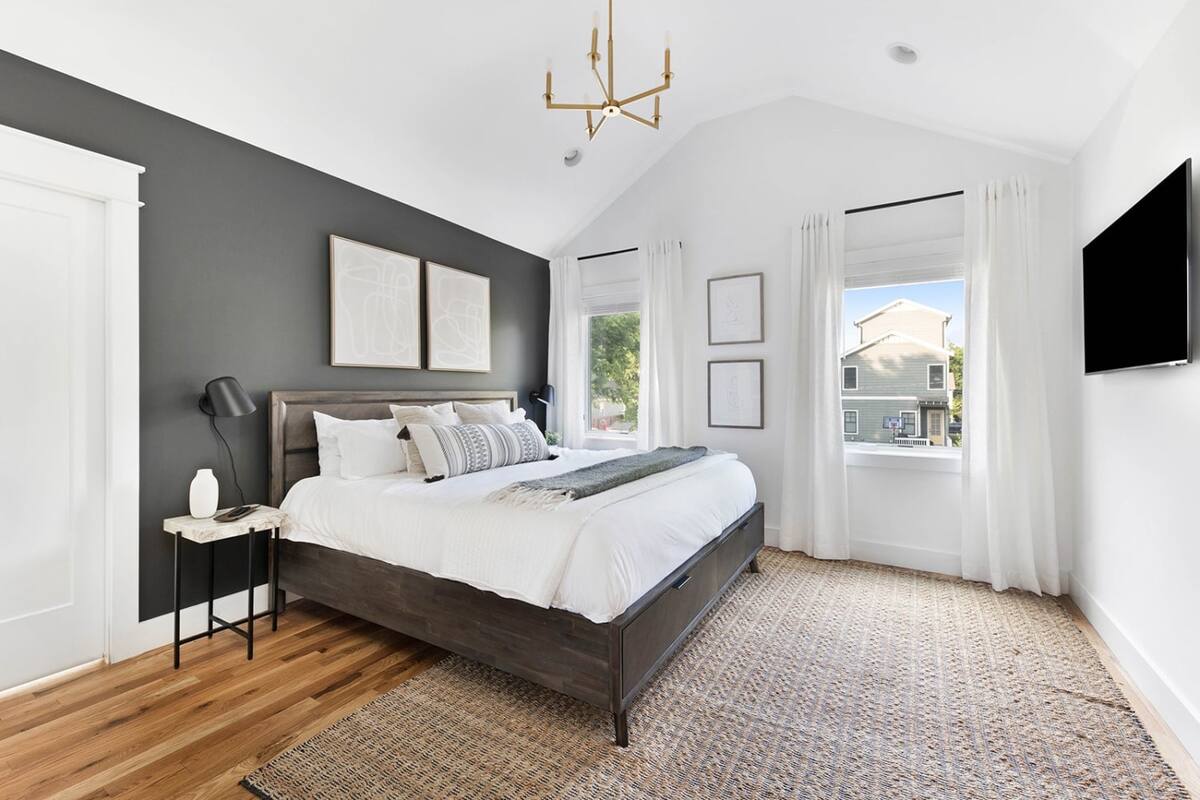 The master bedroom features a wall-mounted smart television, allowing you to stream your favorite movies and shows from the comfort of the king bed.