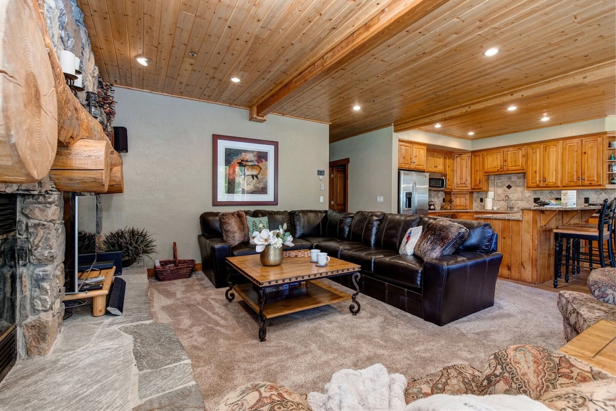 CAPTION: Discover a rustic retreat at "Property" in Park City, US, where cozy elegance meets mountain charm. The interior boasts a warm, inviting atmosphere with wooden ceilings, stone accents, and plush leather seating. Natural earthy tones and soft lighting create a comforting ambiance. Ideal for luxury travelers seeking a serene escape, the property combines traditional design with modern comfort, perfect for enjoying the winter landscapes or summer mountain adventures.