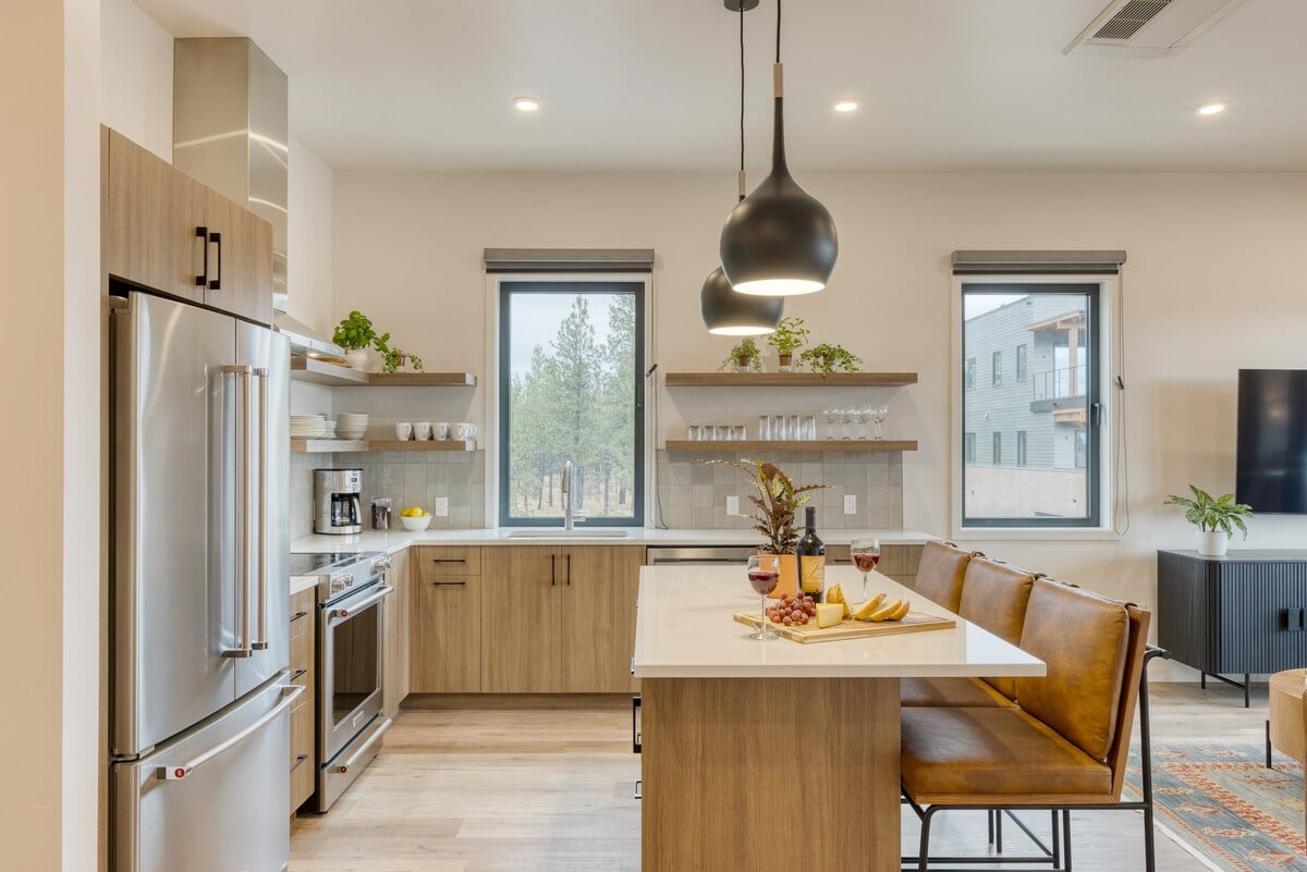 Kitchen view featuring light wood cabinetry, open shelving, and stainless steel appliances.