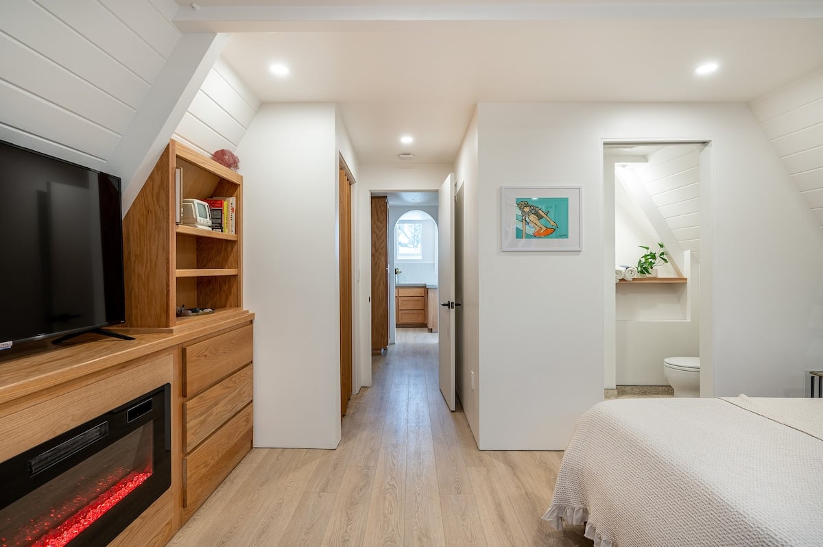 Primary bedroom is located downstairs and features a very comfortable King Size Bed with Smart TV + Fireplace + its own en-suite bathroom with HEATED FLOORS and a super unique shower that utilizes handmade Japanese INAX tiles. 