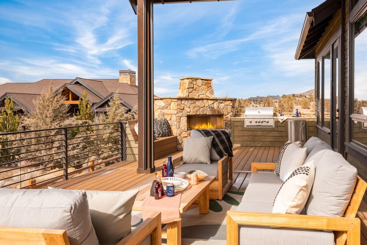 The spacious deck features comfortable seating, an outdoor fireplace, and a BBQ grill.
