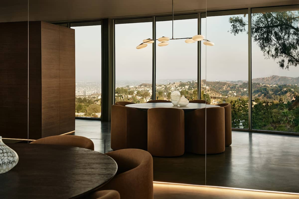 Dine at the sleek table with exquisite RH Modern chairs, surrounded by stunning views of the city skyline.