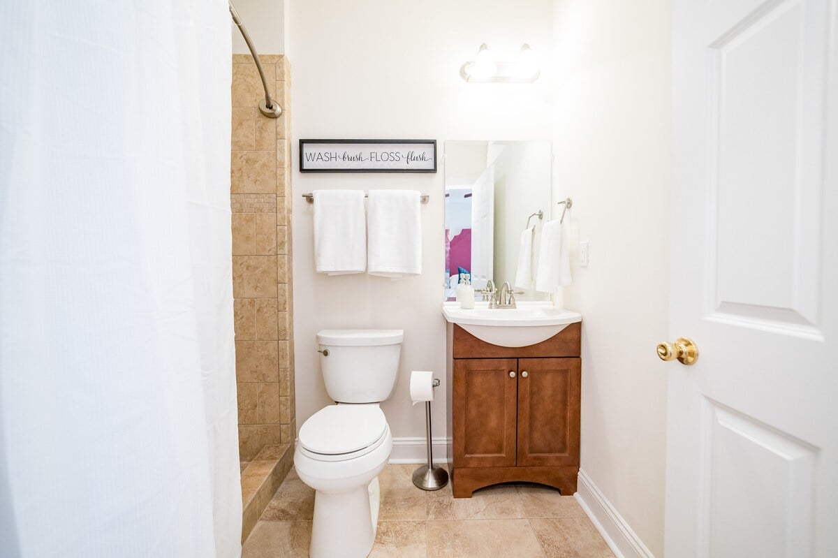 Gala bathroom has a sink vanity, toilet, and large tiled shower.