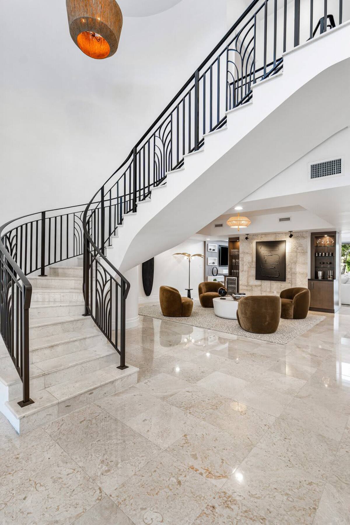 Elegant staircase with custom wrought-iron details and polished stone steps for a luxurious entrance.