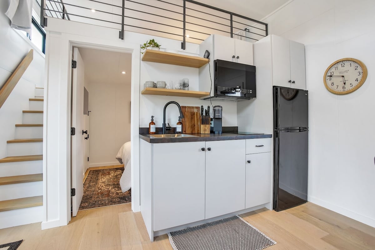 This is a full kitchen equipped with a stove, fridge and fully-stocked with anything you'll need to prepare a meal in! The dining space seats 4.