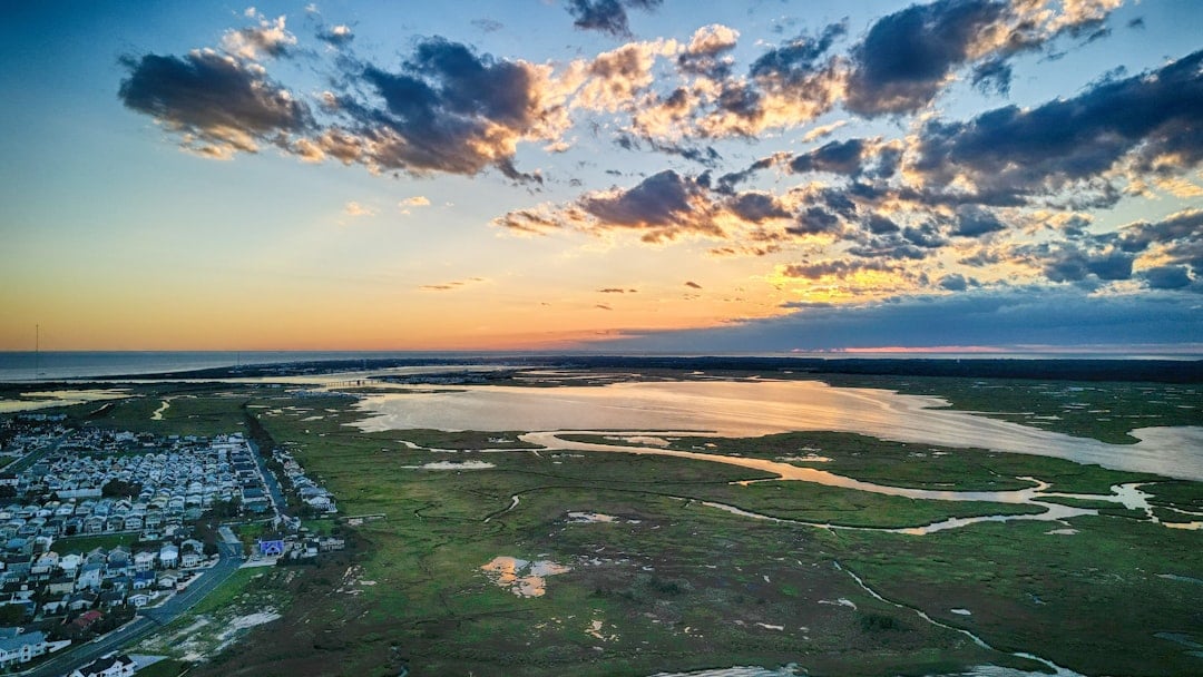 a landscape with a body of water and land with buildings in the distance
