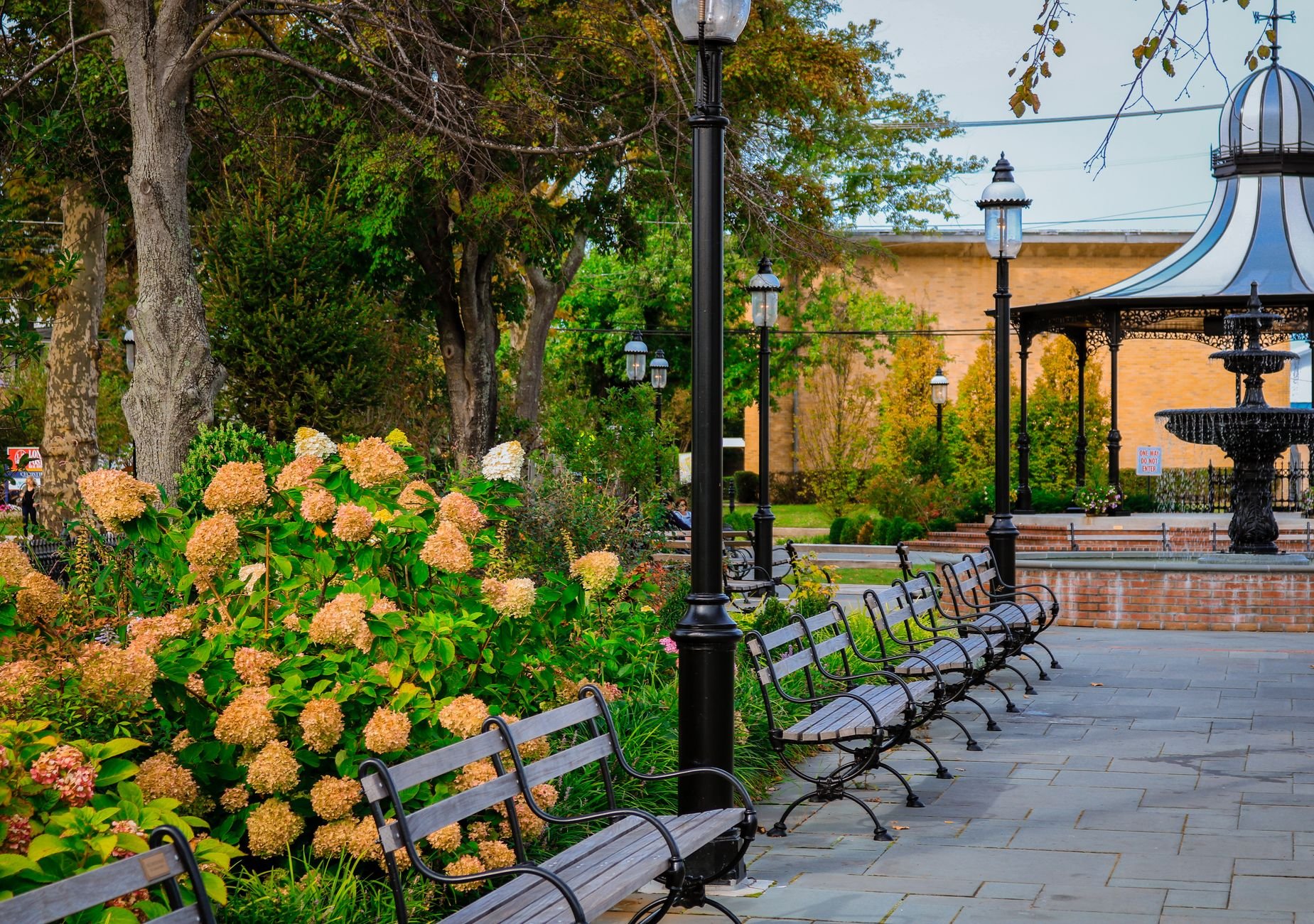 A peaceful park setting with a gazebo, flowers, and benches in Cape May, NJ.