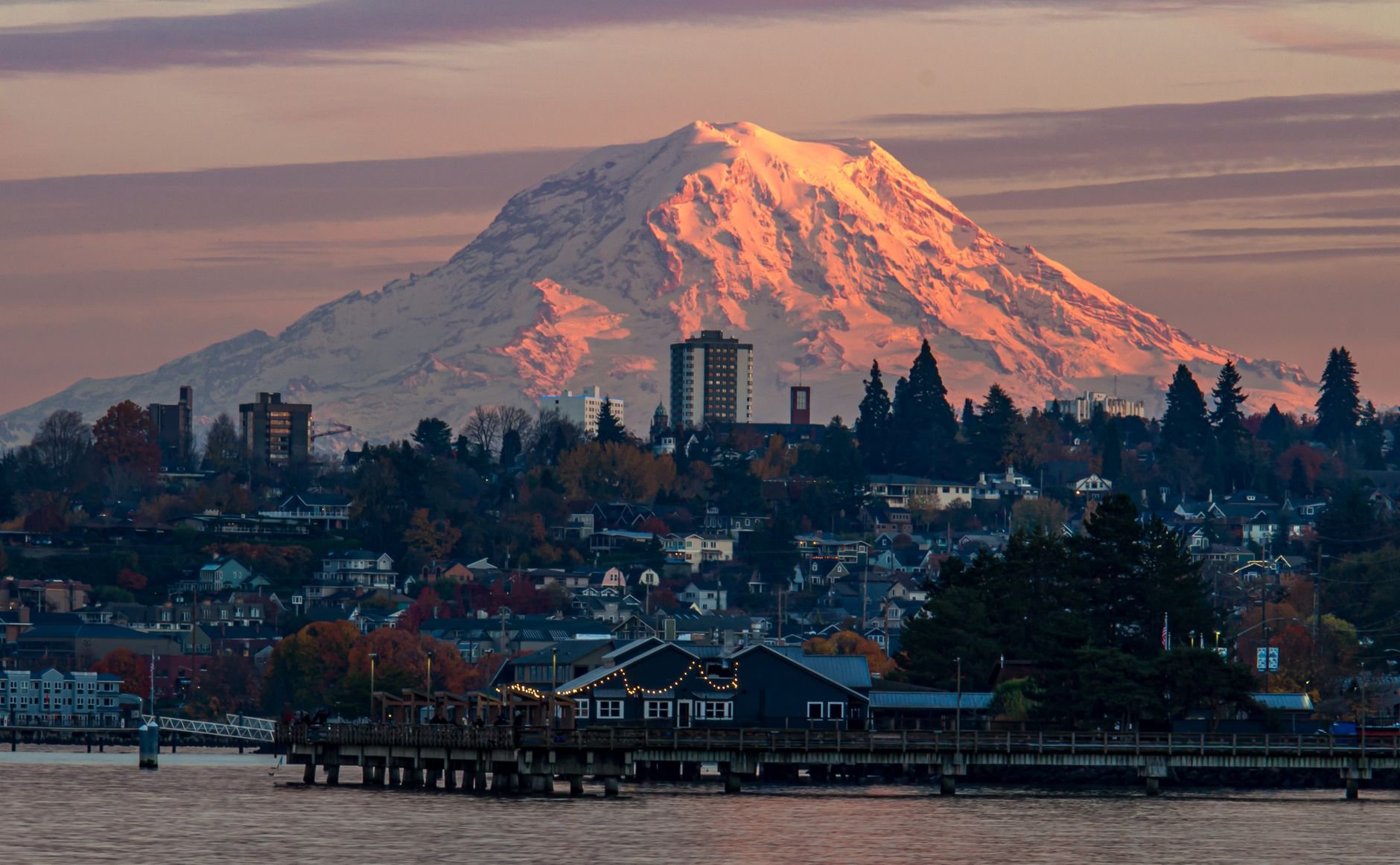 Sunset view of Mount Rainier towering over Tacoma's waterfront with vibrant autumn colors.