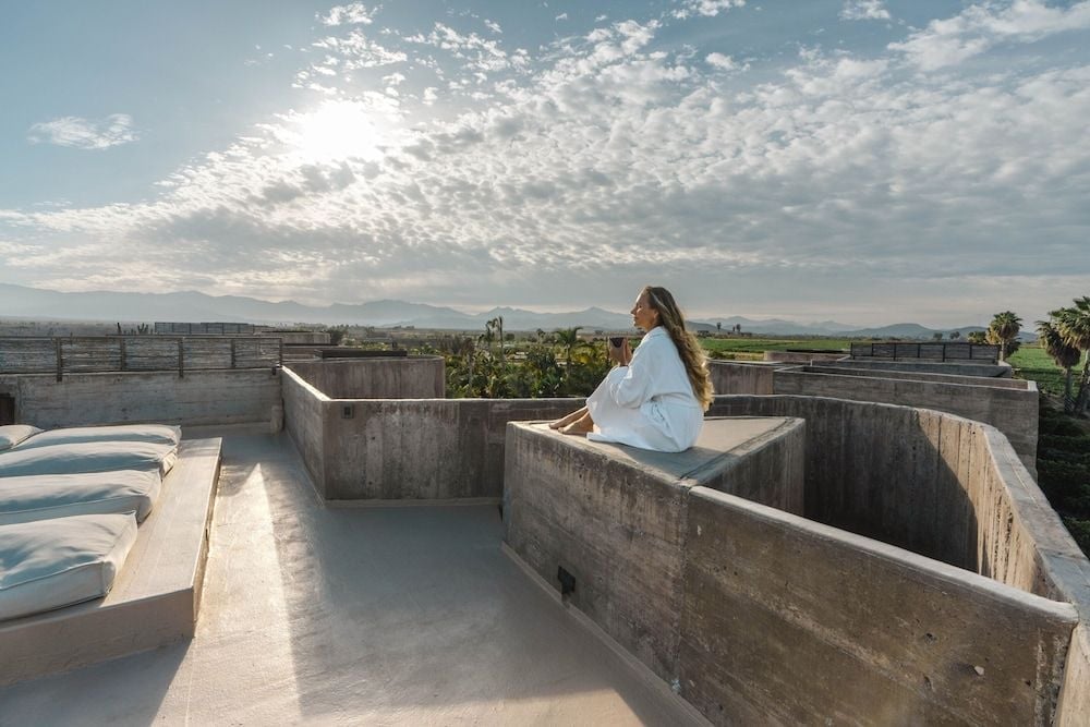 Raw concrete soaking tubs carved into the rooftop terrace frame endless desert vistas, where golden hour light transforms utilitarian materials into sculptural luxury.