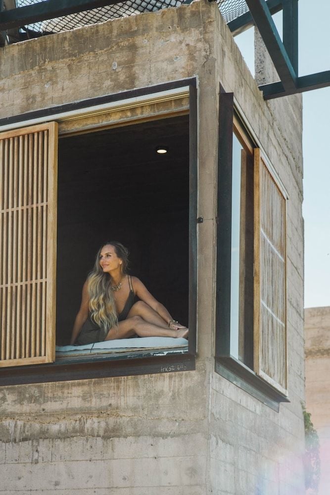 Concrete and wood blend seamlessly in this desert retreat room, where floor-to-ceiling windows frame endless Baja landscapes and invite contemplative moments.