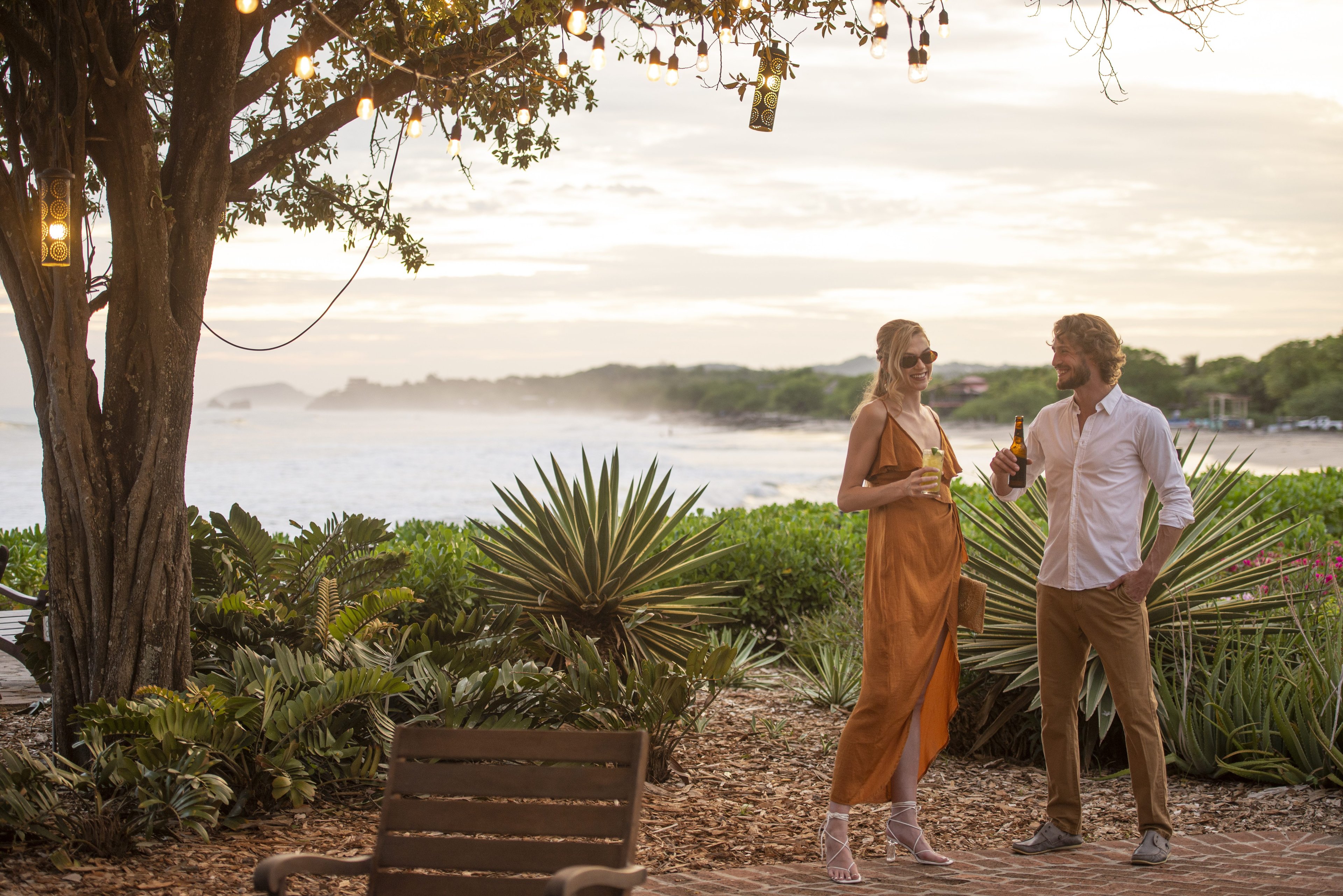 Golden hour cocktails beneath string lights and tropical palms create intimate moments overlooking Nicaragua's Pacific coastline at this luxury resort sanctuary.