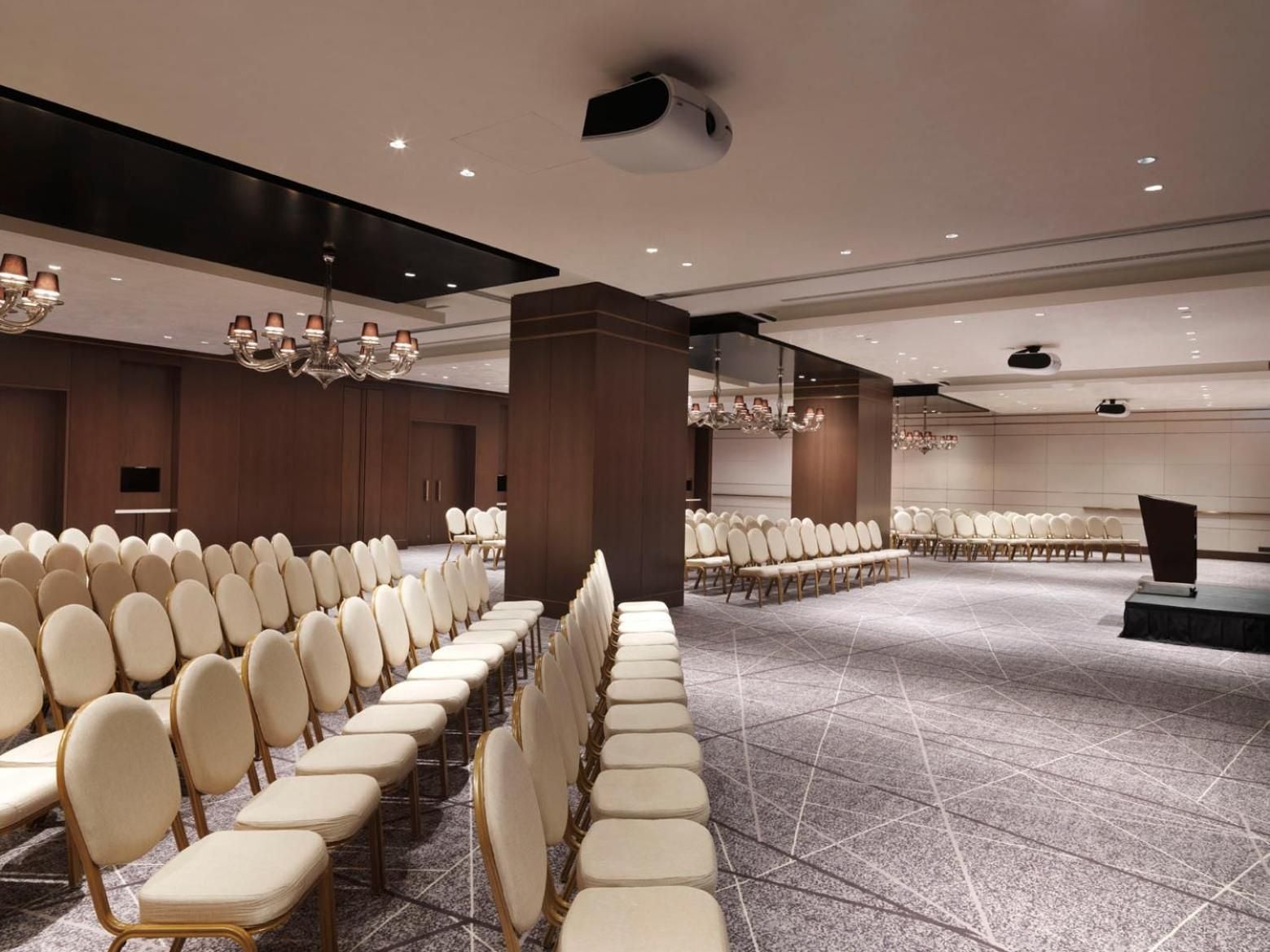 Sophisticated conference facilities blend warm wood paneling with crystal chandeliers and cream leather seating, creating an unexpectedly elegant atmosphere for business gatherings.