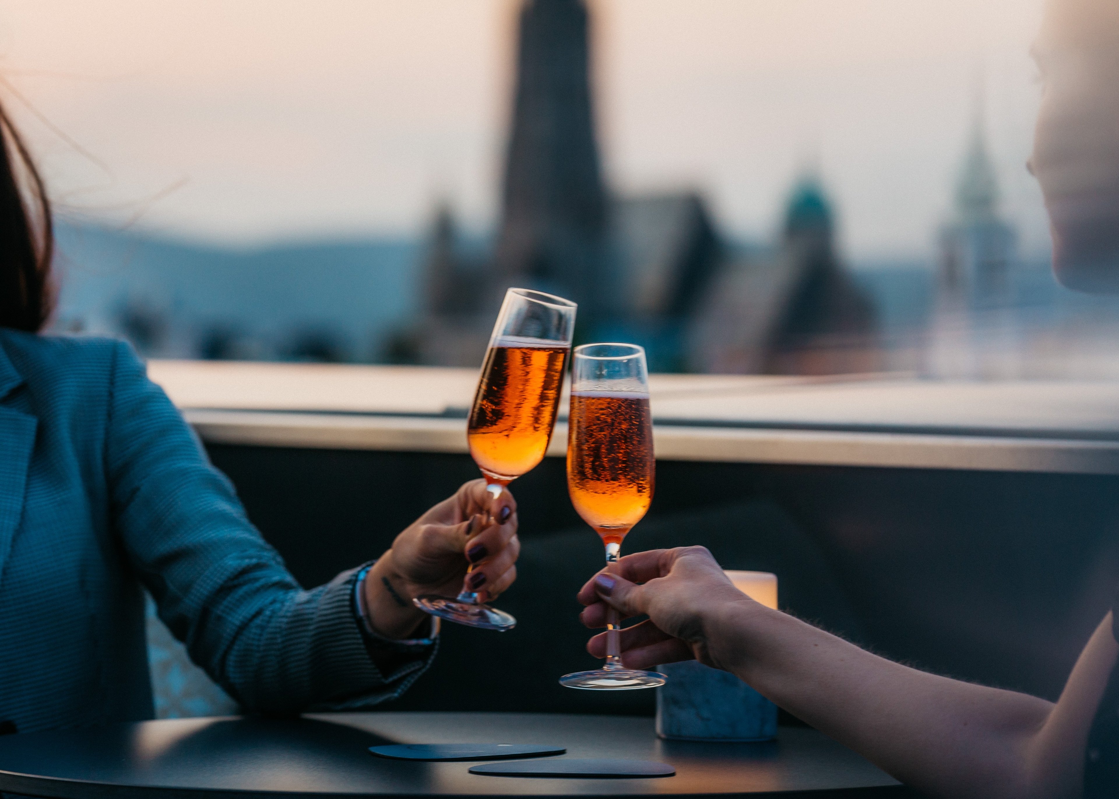 Golden champagne catches Manhattan's twilight glow as guests toast amid the sophisticated ambiance of this elevated lounge overlooking Central Park's leafy canopy.