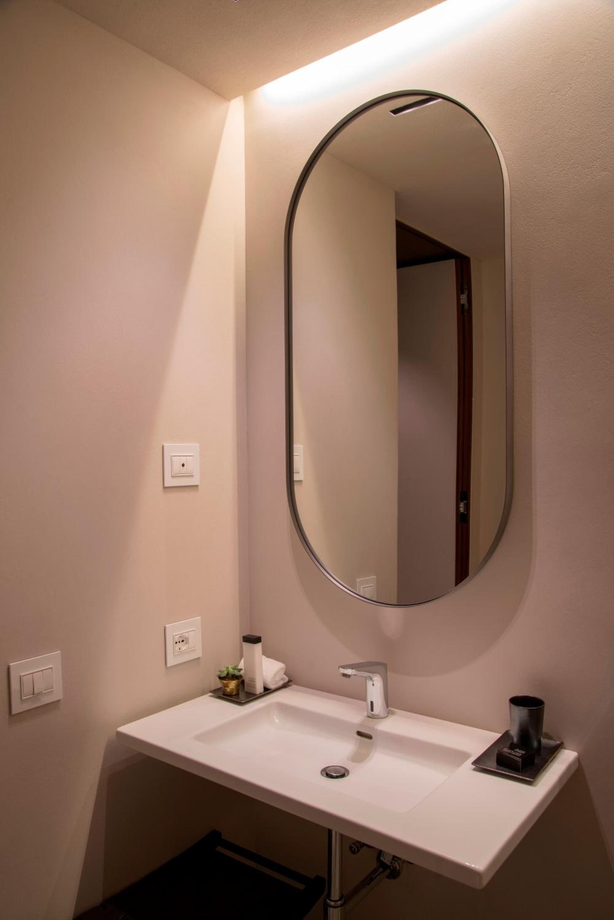 Soft pink-hued walls create an intimate cocoon around the floating vanity, while warm accent lighting transforms this powder room into a serene sanctuary.