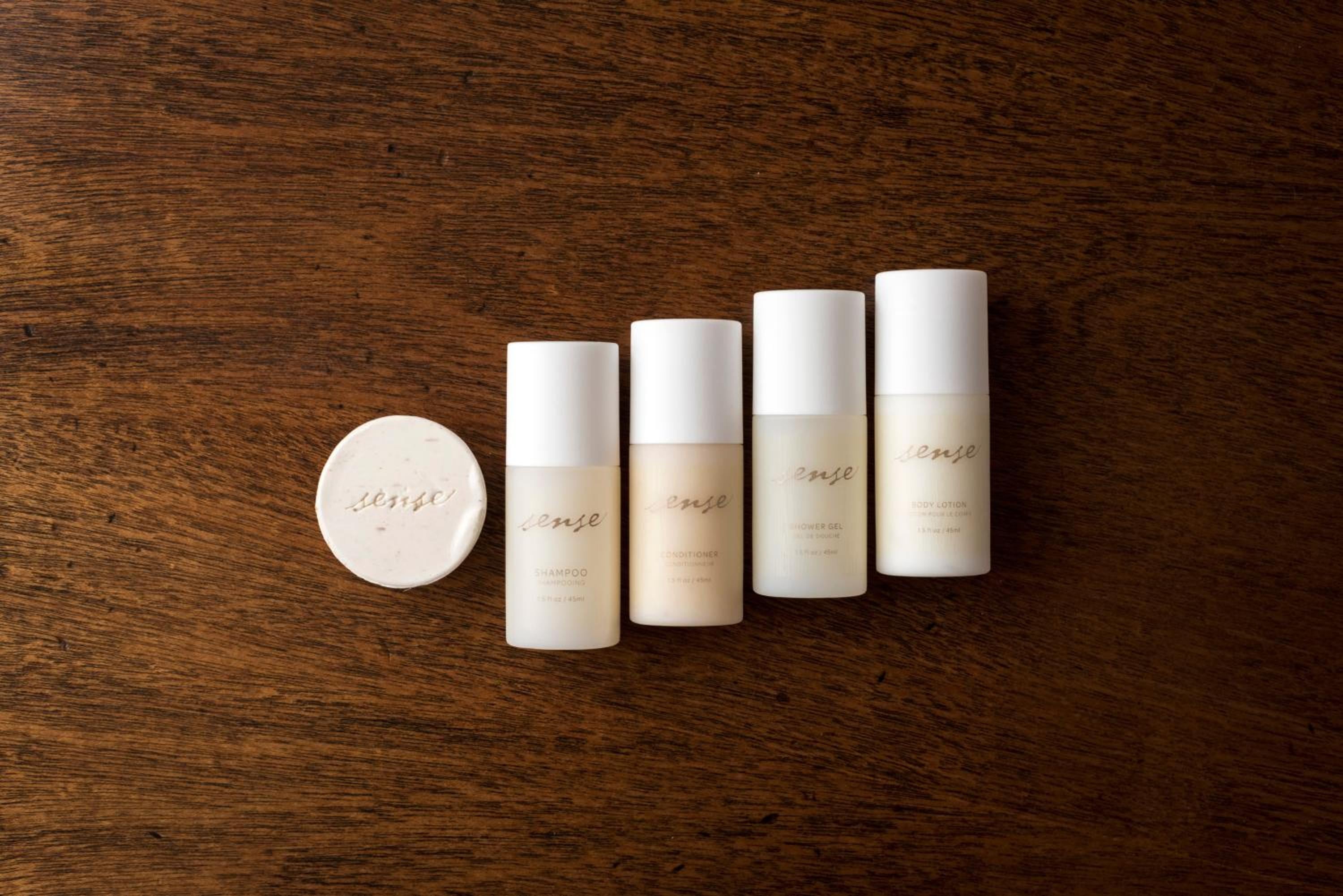 Minimalist luxury amenities line up like soldiers on rich walnut, each pristine bottle promising indulgent rituals in this thoughtfully curated guest experience.