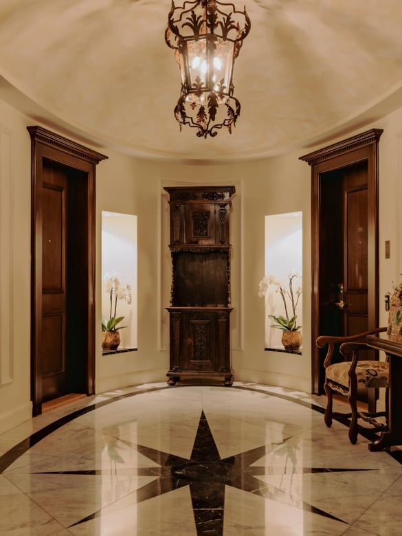 Gleaming marble inlays and ornate bronze lanterns create an intimate rotunda where Old World craftsmanship meets alpine grandeur in this storied palace foyer.