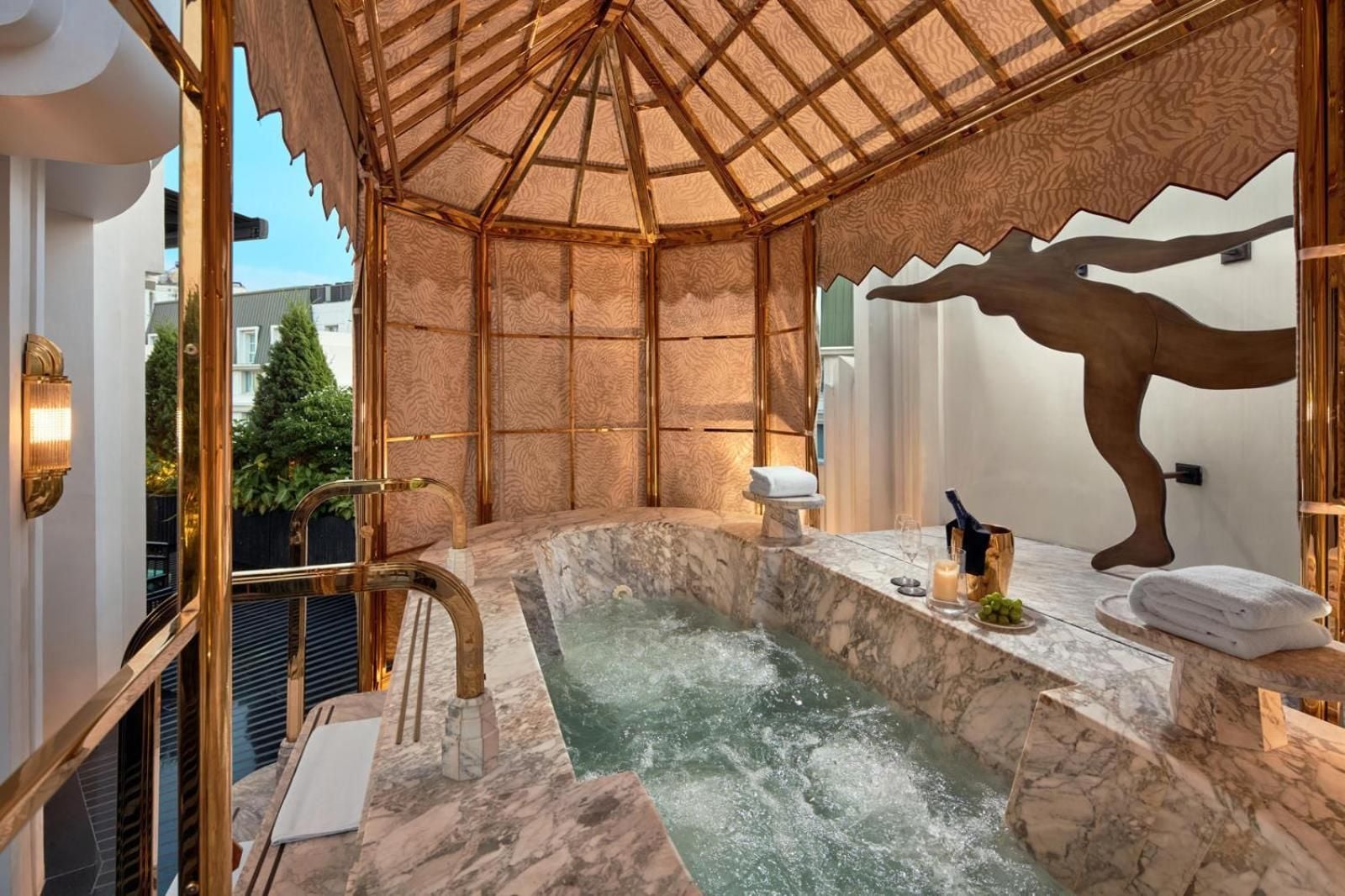 Carved wood panels and marble surround the intimate spa jacuzzi, where golden light filters through traditional screens creating a serene urban sanctuary.