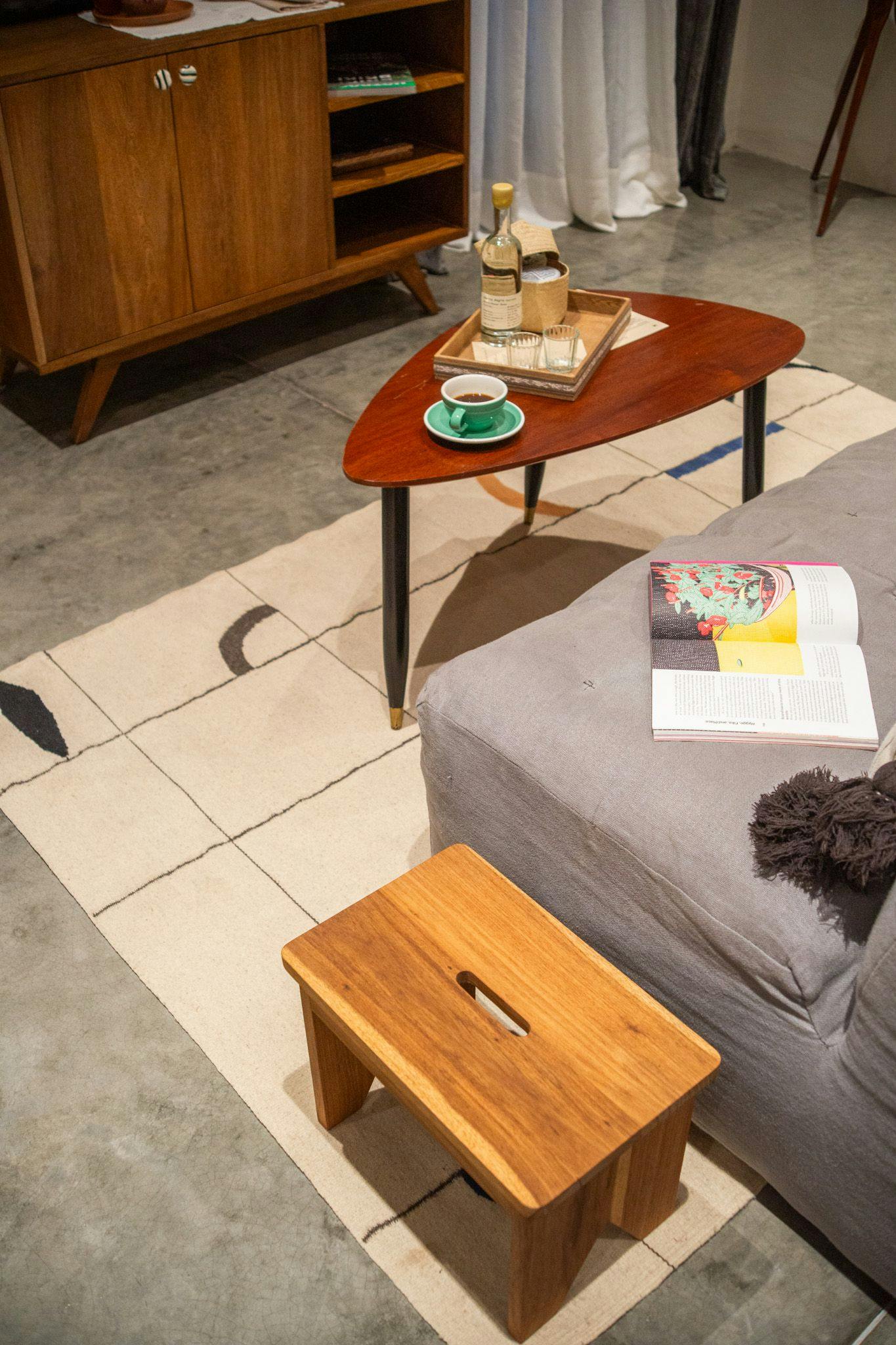 Mid-century modern furnishings create intimate conversation nooks, where teak side tables hold morning espresso and well-thumbed magazines catch afternoon light.