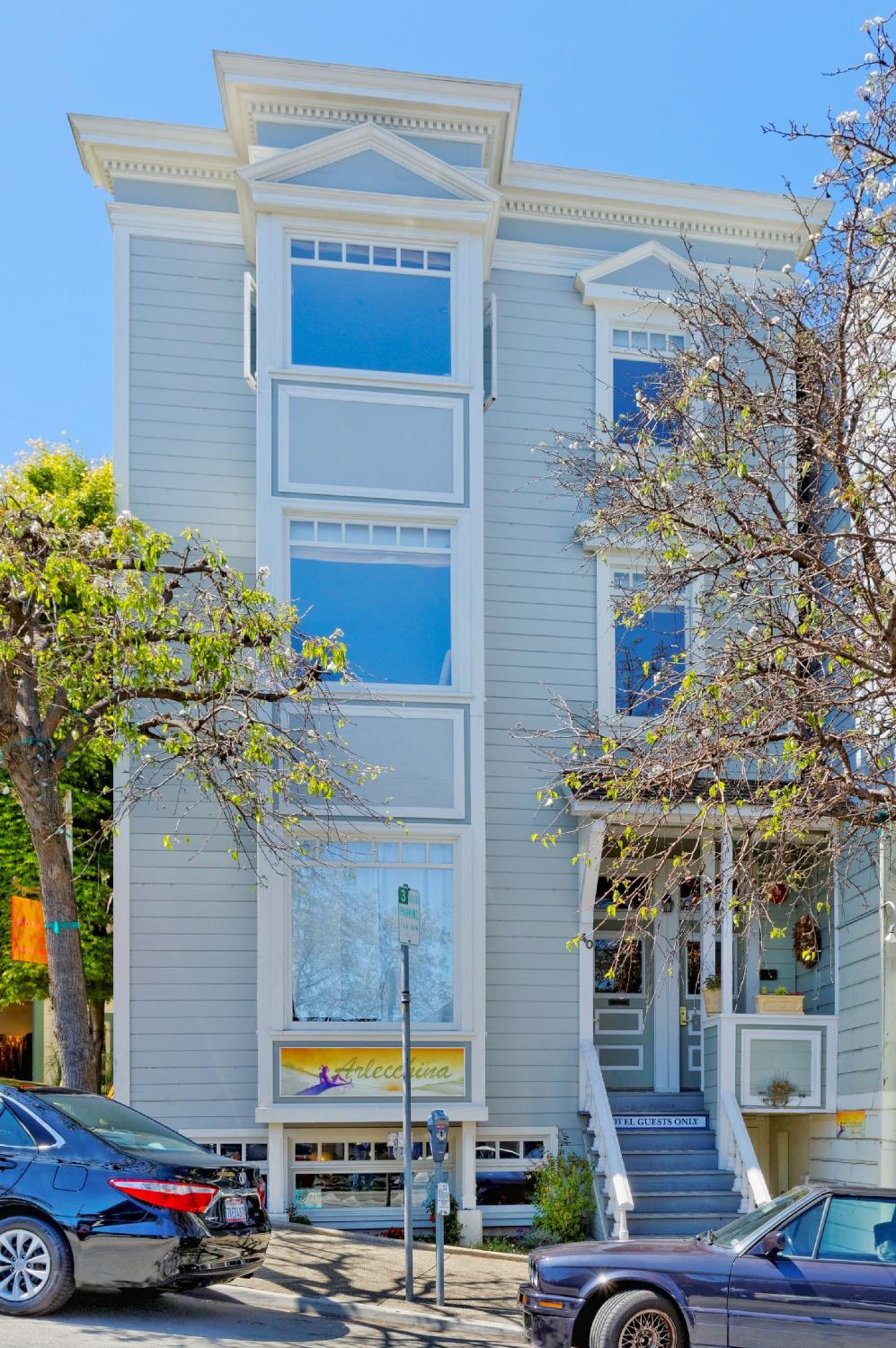 Victorian-era charm meets contemporary comfort in this elegant gray clapboard facade, where ornate trim and towering bay windows create timeless Sausalito sophistication.