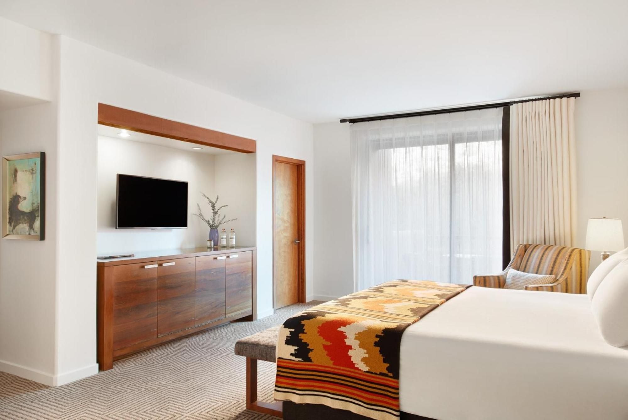 Warm wood cabinetry and vibrant Southwestern textiles create an inviting retreat where modern amenities blend seamlessly with regional artistry and desert-inspired design.