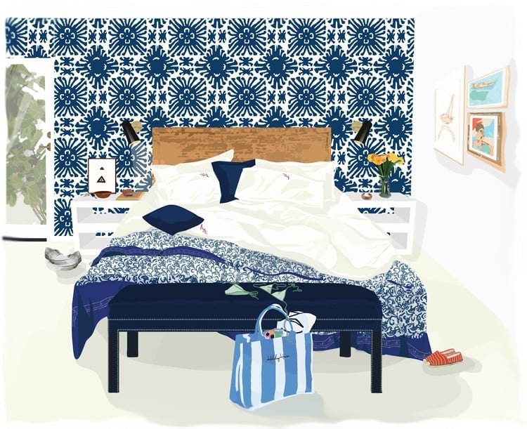 Bold navy botanicals create drama against crisp white linens, while natural wood headboards and striped beach bags hint at coastal escapes just beyond.