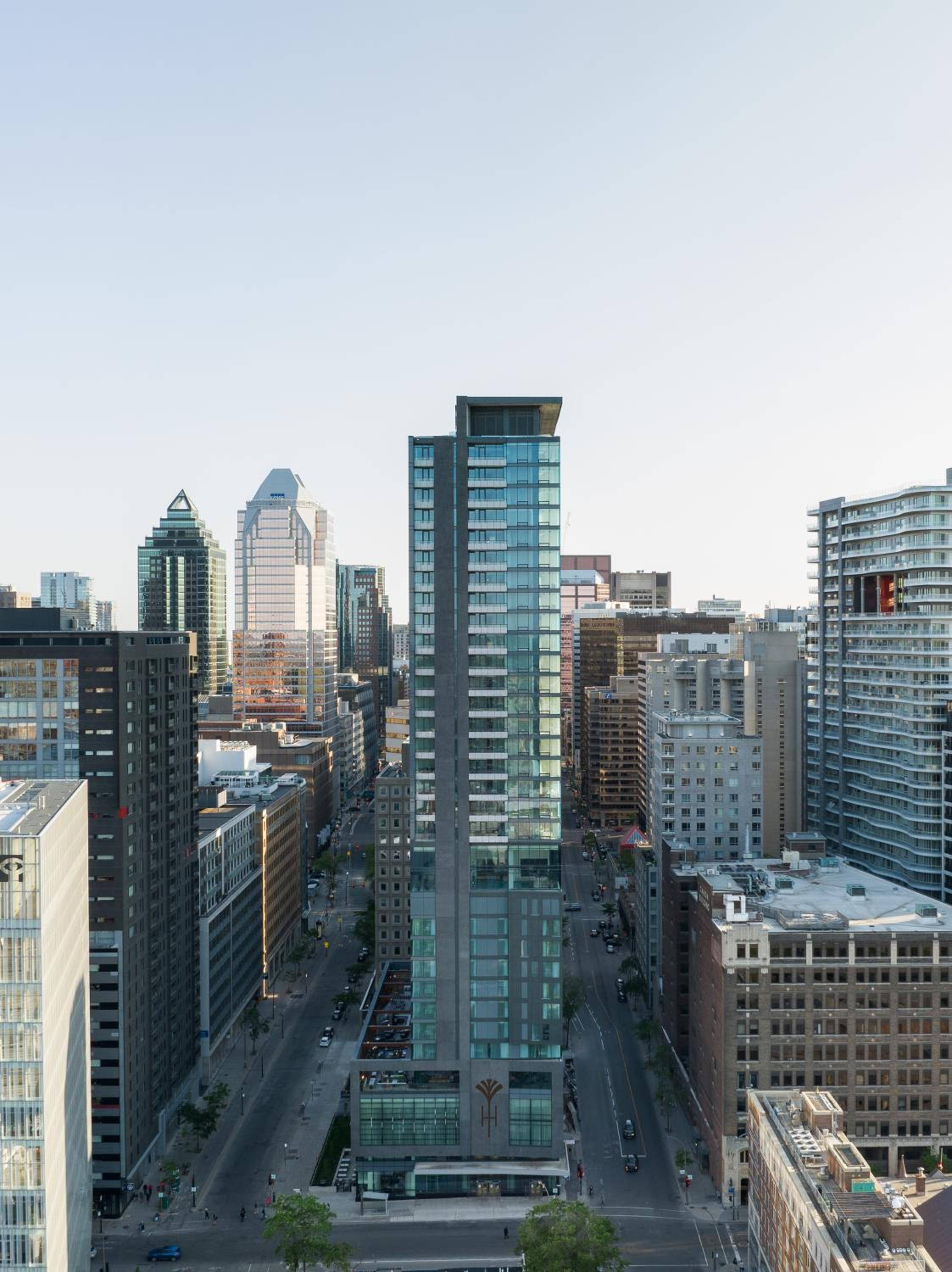 Glass towers pierce the twilight sky as Montreal's dynamic downtown unfolds below, revealing the urban energy that surrounds this striking contemporary hotel.