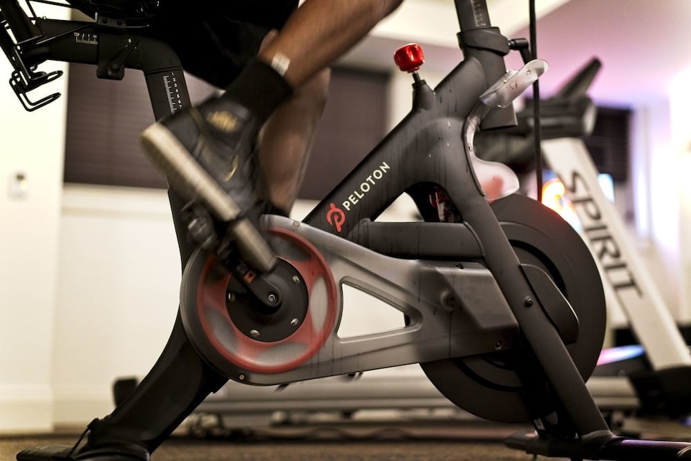 Peloton bikes anchor the hotel's sleek fitness center, where polished concrete floors and industrial lighting create an energizing urban workout sanctuary.