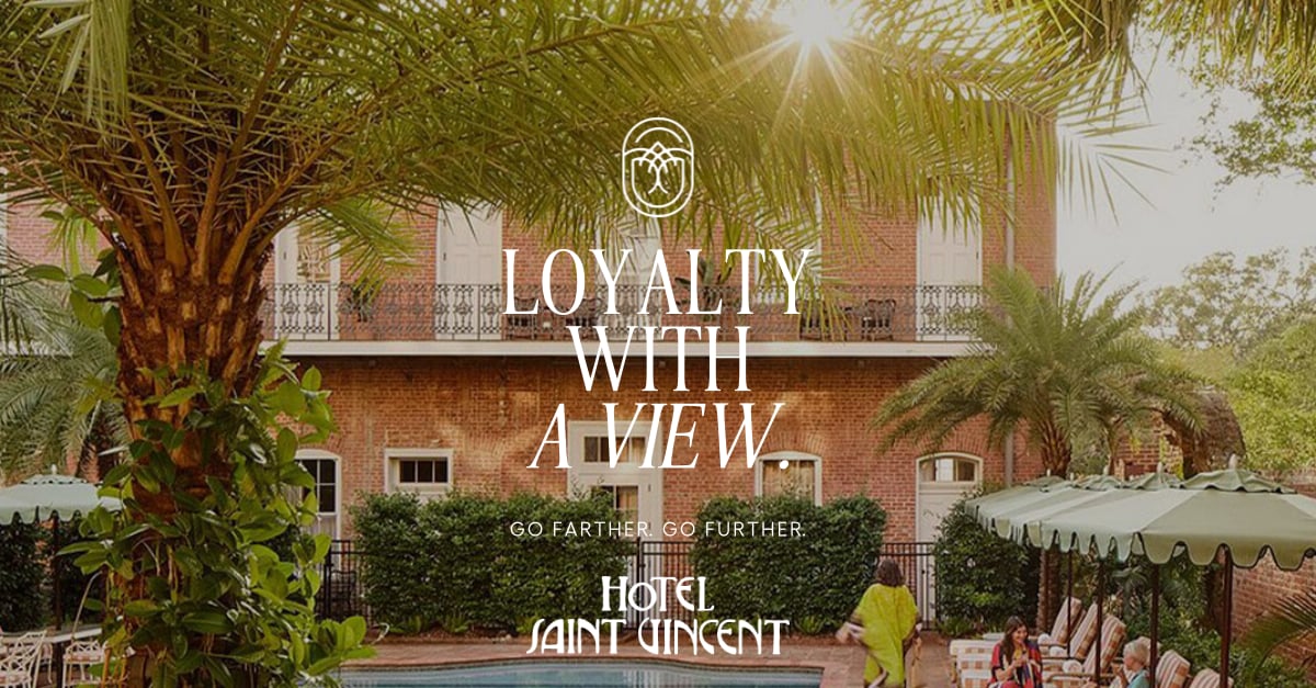 Sunlight filters through palm fronds at the poolside oasis, where brick architecture and tropical gardens create an intimate escape from New Orleans' bustling French Quarter below.