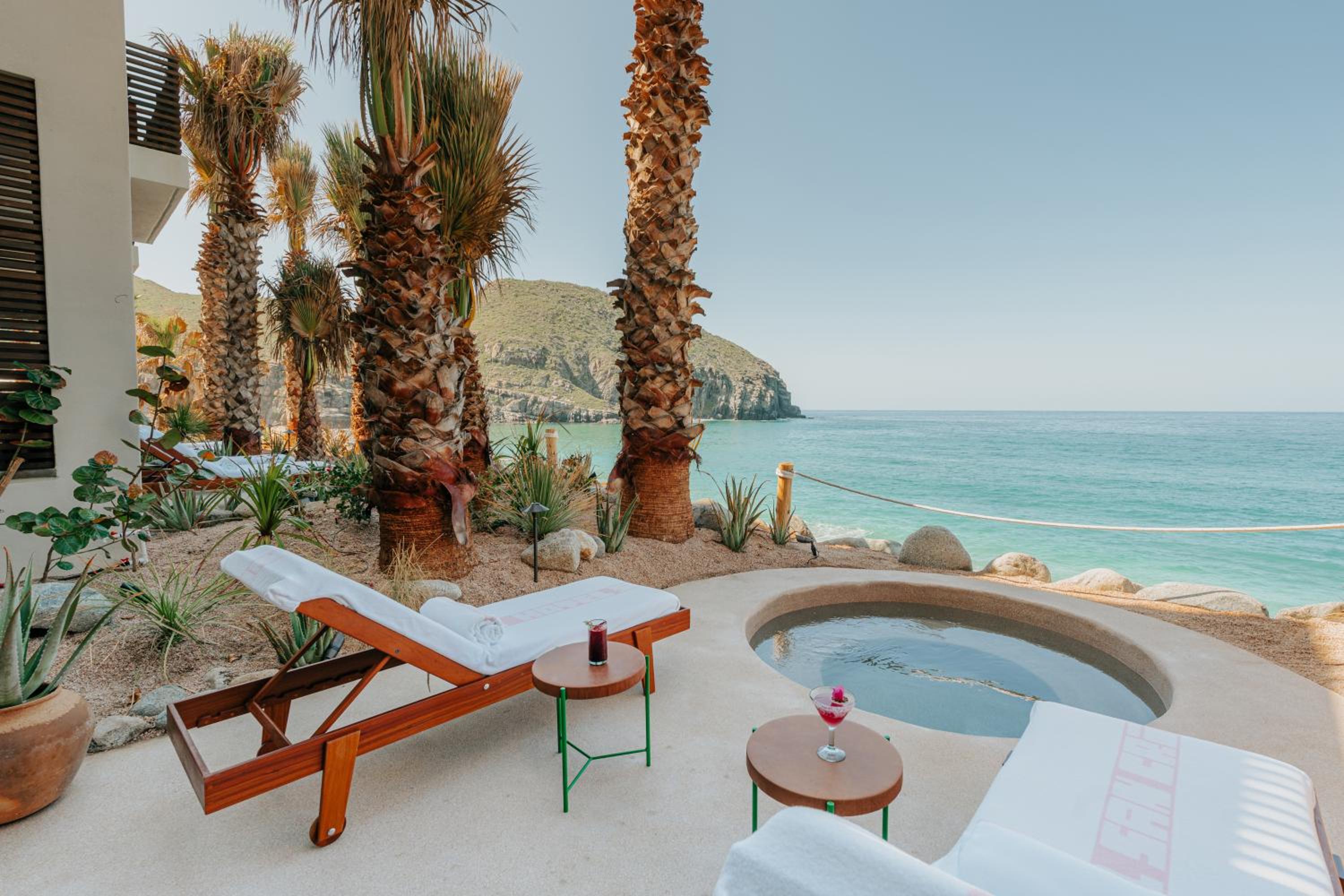 Palm-fringed tranquility meets Pacific drama from this oceanfront suite's private plunge pool, where desert landscaping frames crystalline waters and distant headlands.