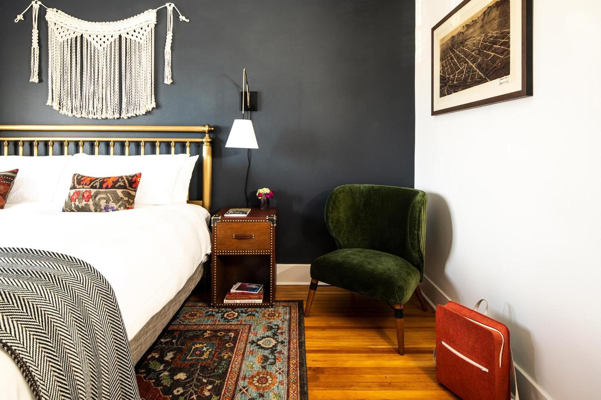 Macramé wall hangings and jewel-toned velvet create an intimate reading nook, where brass bed frames meet Persian rugs on gleaming hardwood floors.