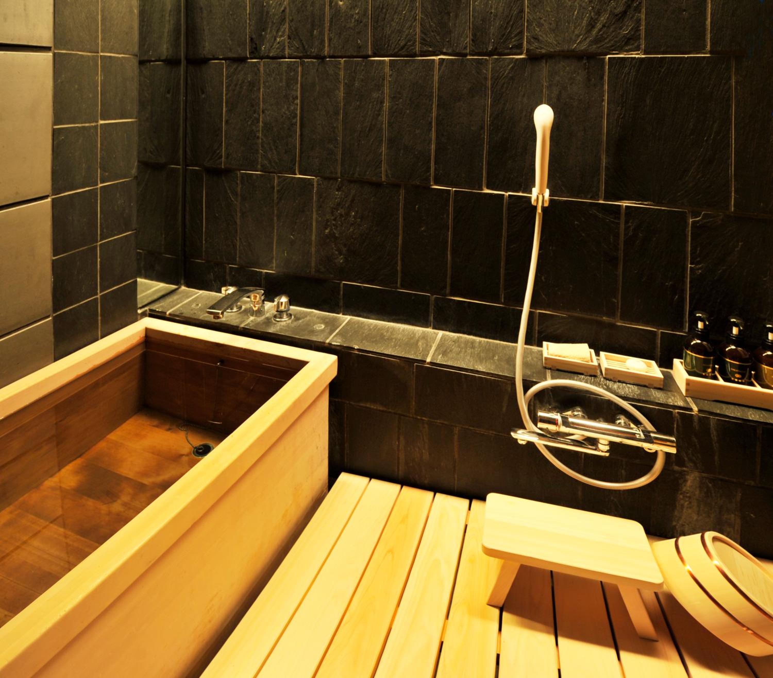 Hinoki cypress wood meets sleek black stone in this intimate bathing sanctuary, where traditional Japanese soaking rituals blend seamlessly with contemporary luxury.