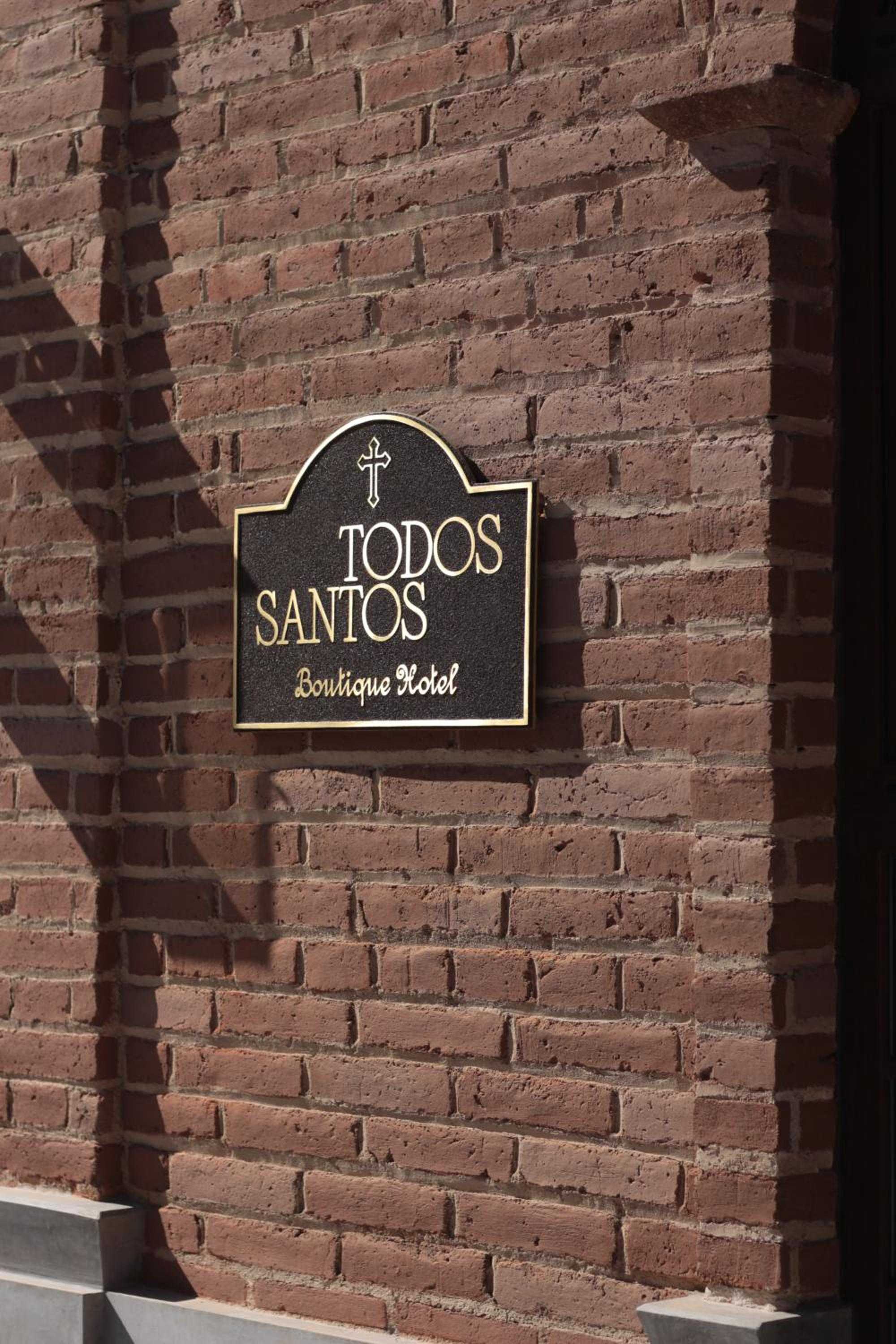 Weathered brick walls frame the elegant bronze nameplate of this intimate boutique property, where colonial charm meets contemporary sophistication in Mexico's artistic haven.