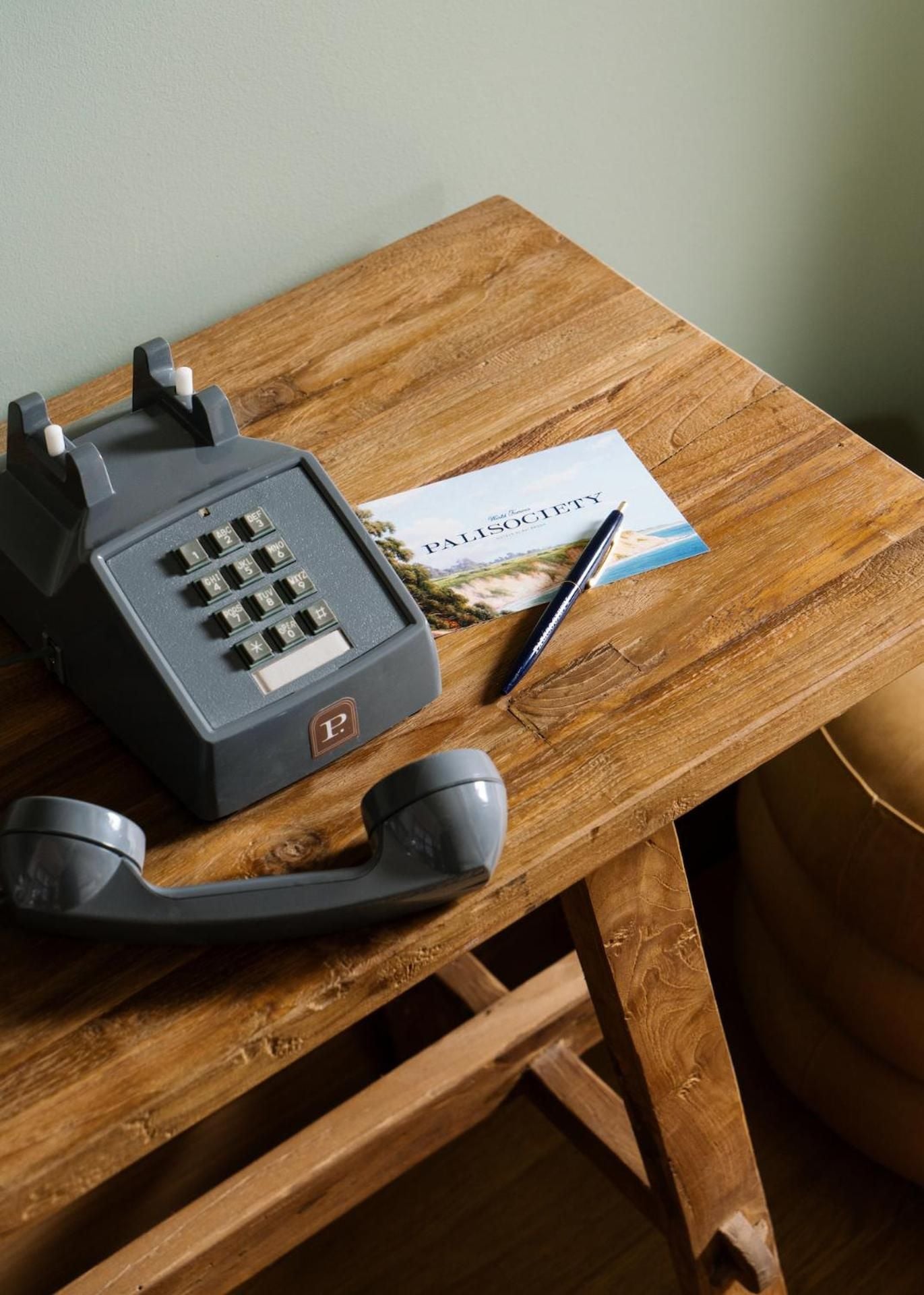 Vintage rotary phone and handwritten postcards on weathered wood evoke a slower pace, where analog charm meets thoughtful hospitality in every carefully curated corner.