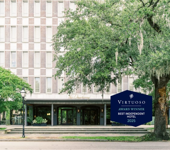 Mid-century elegance meets Southern charm beneath ancient live oaks, where The Dewberry's limestone facade creates a sophisticated urban oasis in downtown Charleston.