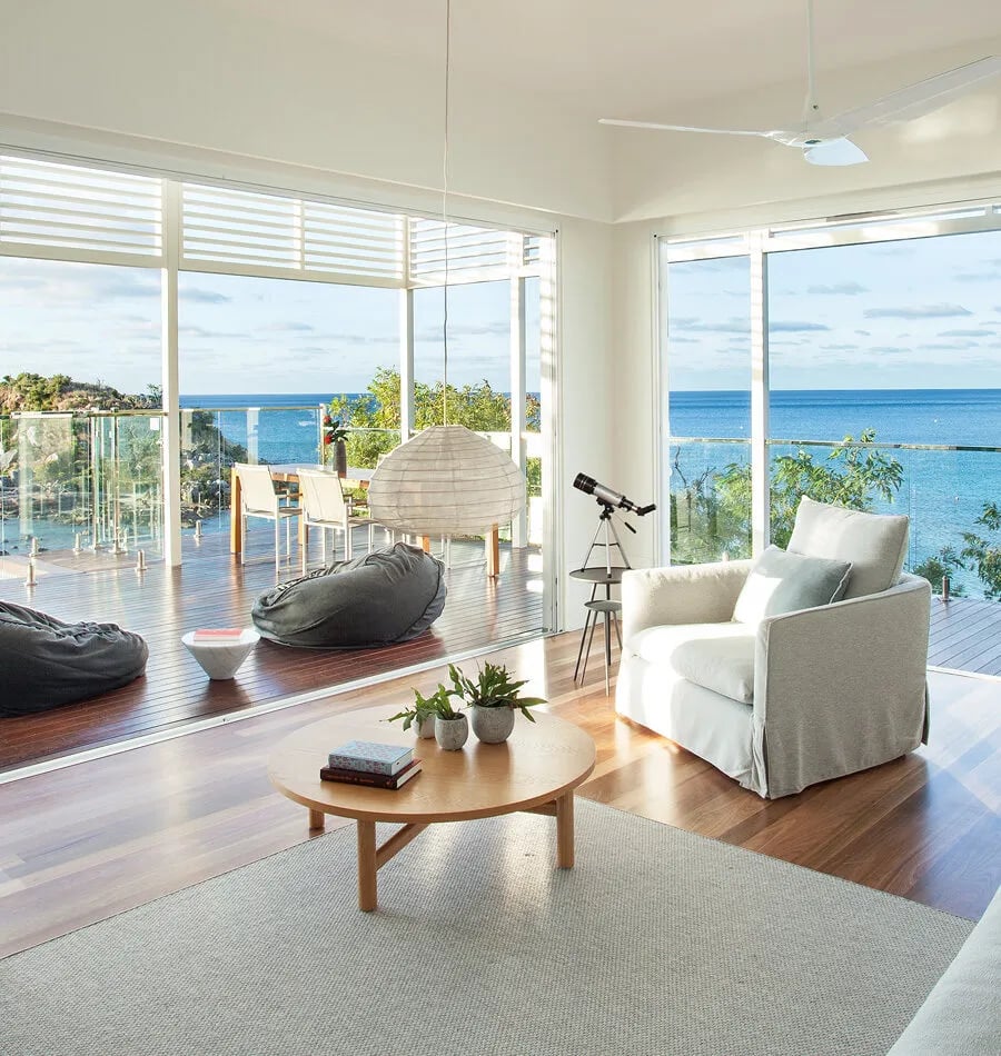 Floor-to-ceiling windows frame endless Coral Sea views from this oceanfront suite, where polished timber floors and coastal breezes create pure tropical serenity.