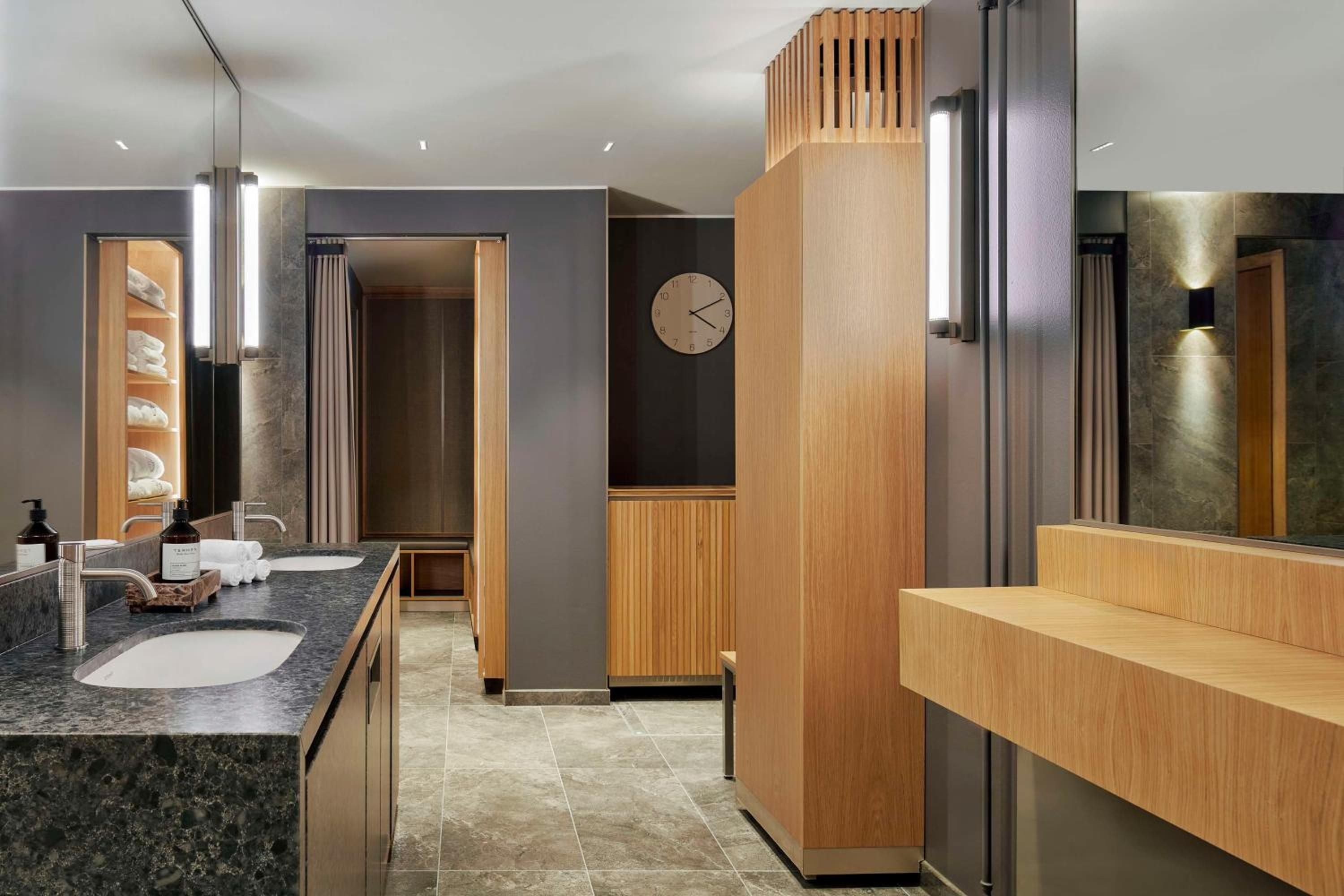 Warm timber accents and charcoal stone create a spa-like sanctuary where Nordic minimalism meets luxurious functionality in this thoughtfully designed bathroom suite.