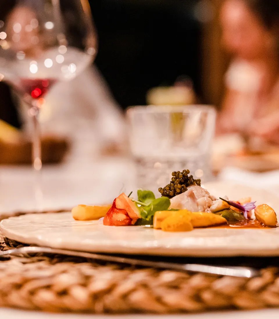 Artfully plated dishes crowned with glistening caviar showcase the culinary finesse, while candlelit tables and crystal stemware create an intimate dining atmosphere.