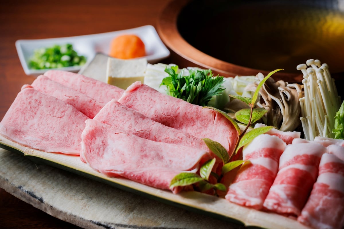 Premium wagyu beef arrives artfully arranged alongside seasonal vegetables and mushrooms, ready for the traditional hot pot experience that defines Takinoyu's refined dining ritual.