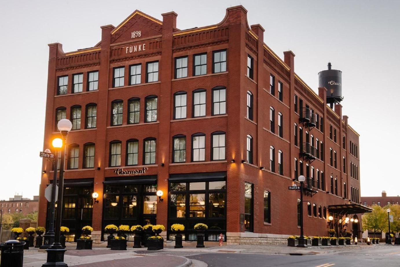 Historic red brick facade glows under street lamps as autumn mums line the entrance to this beautifully restored 1898 building in downtown La Crosse.
