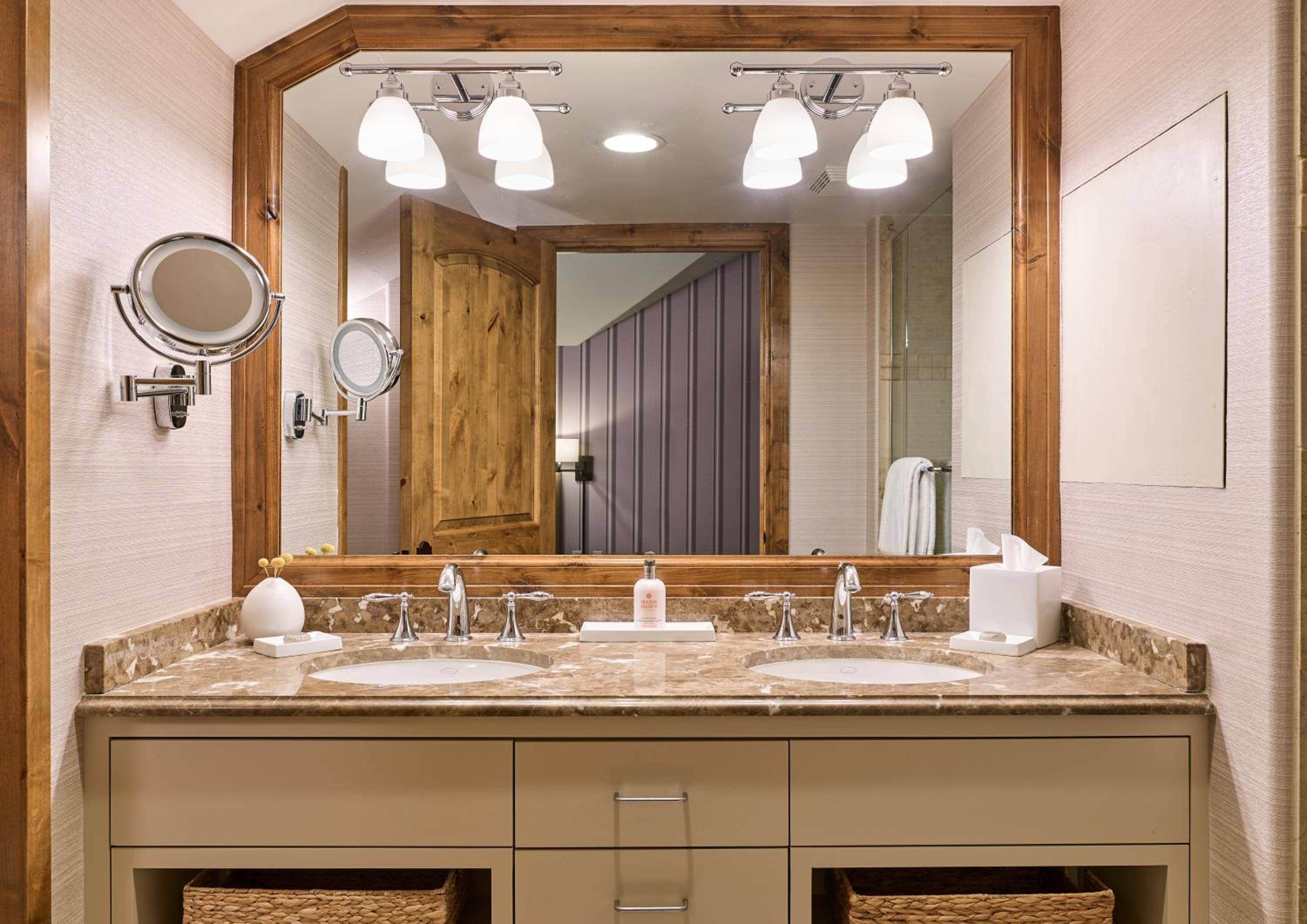 Rich granite countertops and rustic wood framing create a sophisticated mountain retreat aesthetic, with dual vanities offering resort-level luxury in every detail.