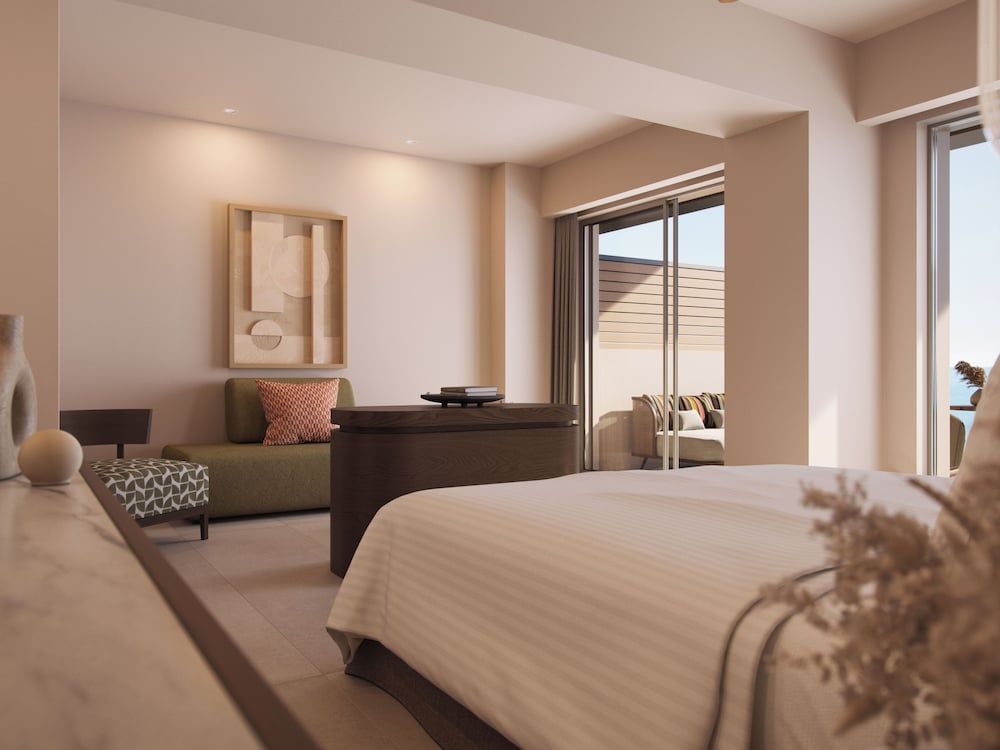 Warm terracotta walls and exposed beams frame this serene suite, where geometric cushions and contemporary art create an effortlessly sophisticated retreat overlooking the Aegean.