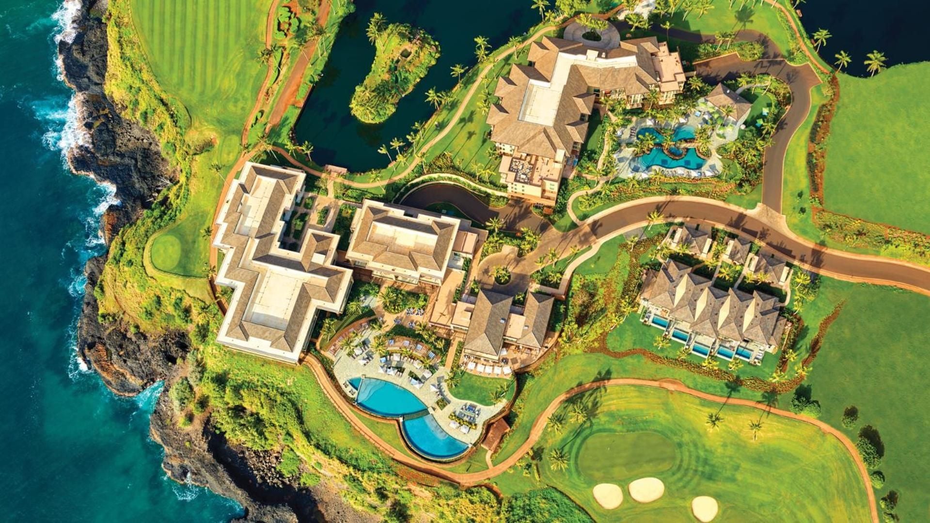 Dramatic clifftop architecture unfolds across emerald fairways, where infinity pools mirror tropical skies and the Pacific's endless blue stretches toward the horizon.