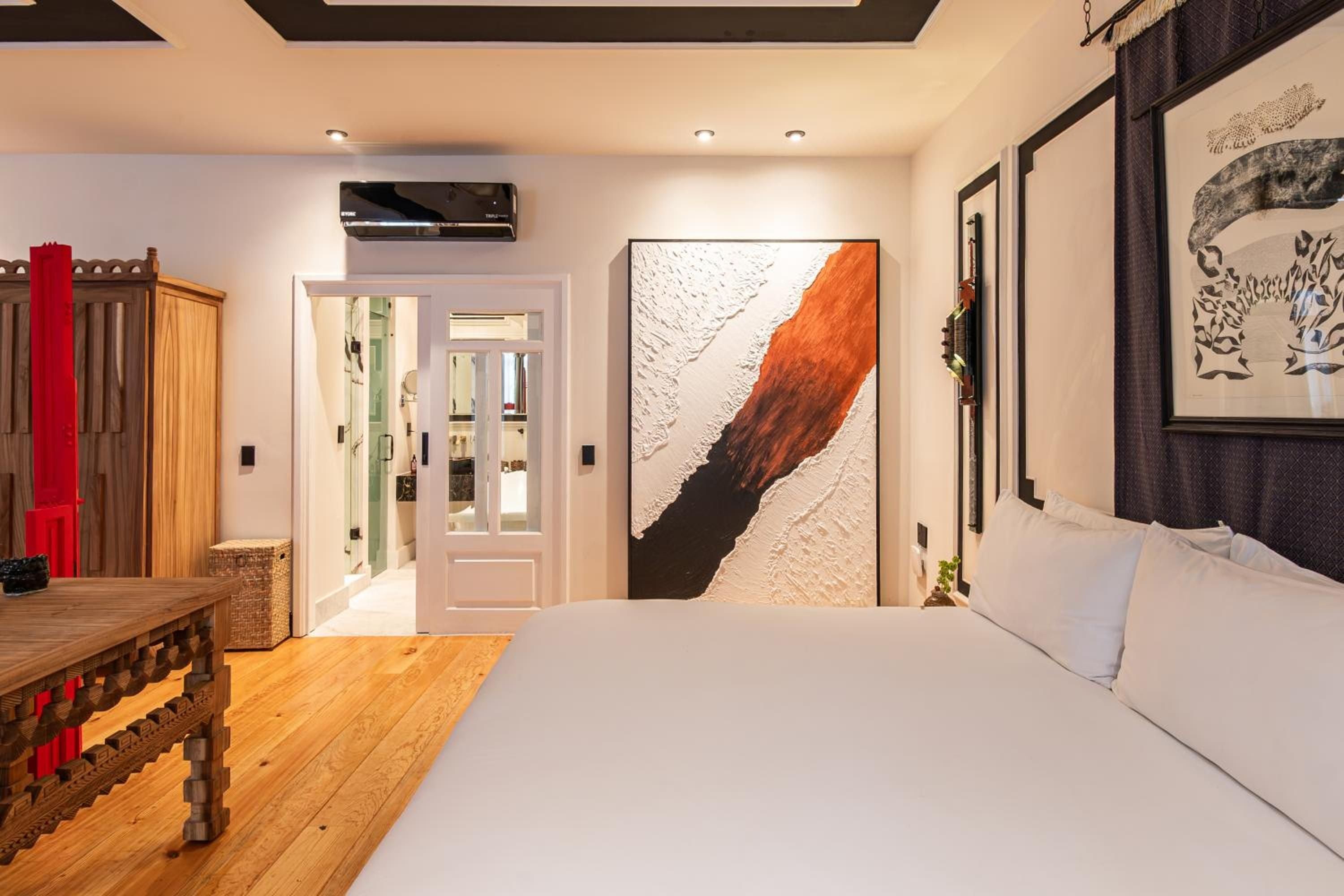 Crisp white linens meet carved wooden furnishings and bold abstract art in this thoughtfully appointed suite, where colonial charm embraces contemporary Mexican design.