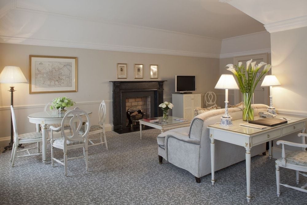 Elegant period details meet contemporary comfort in this spacious suite, where original fireplace, crown molding, and soft gray palette create refined Georgian sophistication.