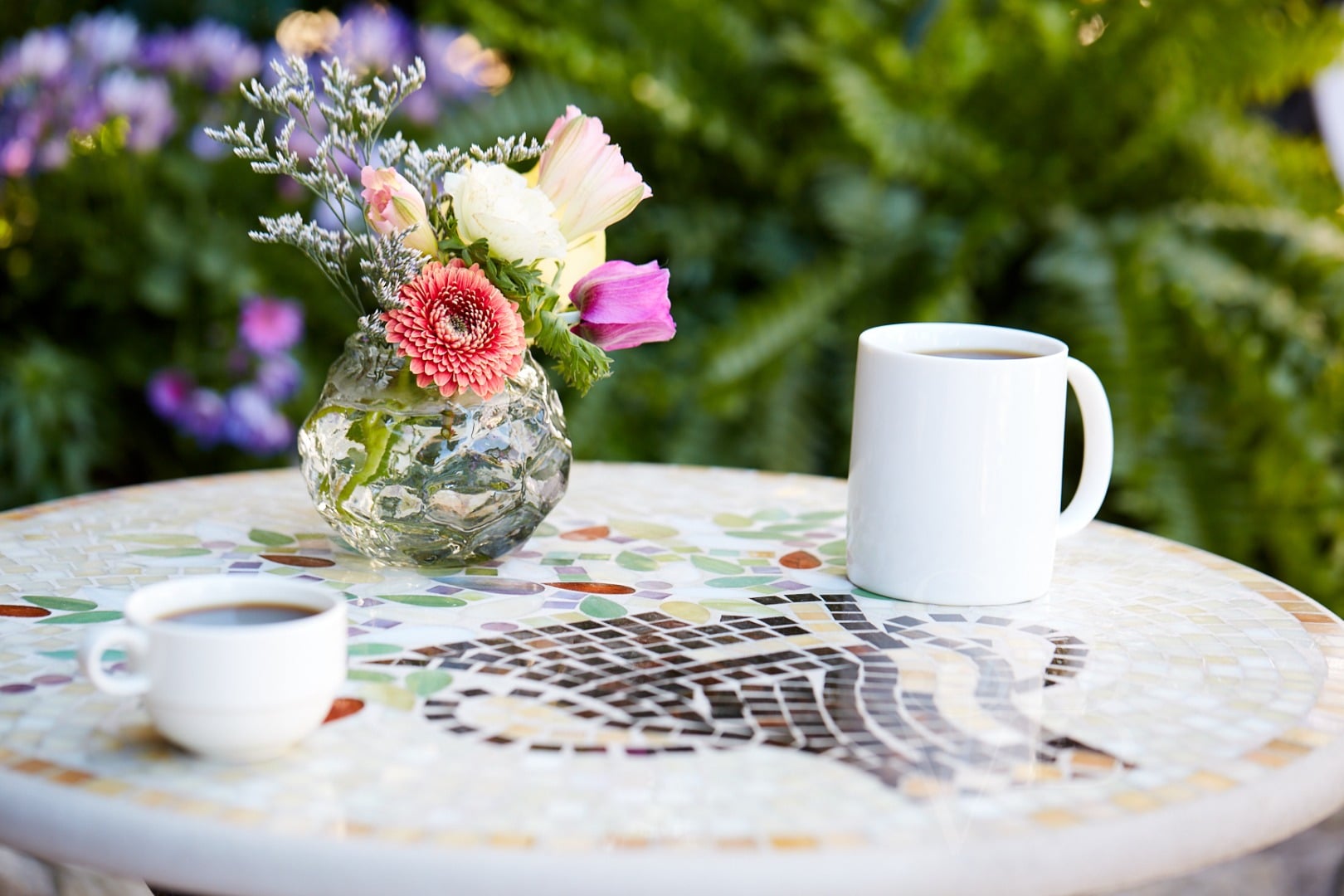 Morning coffee takes on new meaning beside fresh garden blooms on mosaic-tiled tables, where spa serenity meets outdoor dining in perfect Lake Austin harmony.